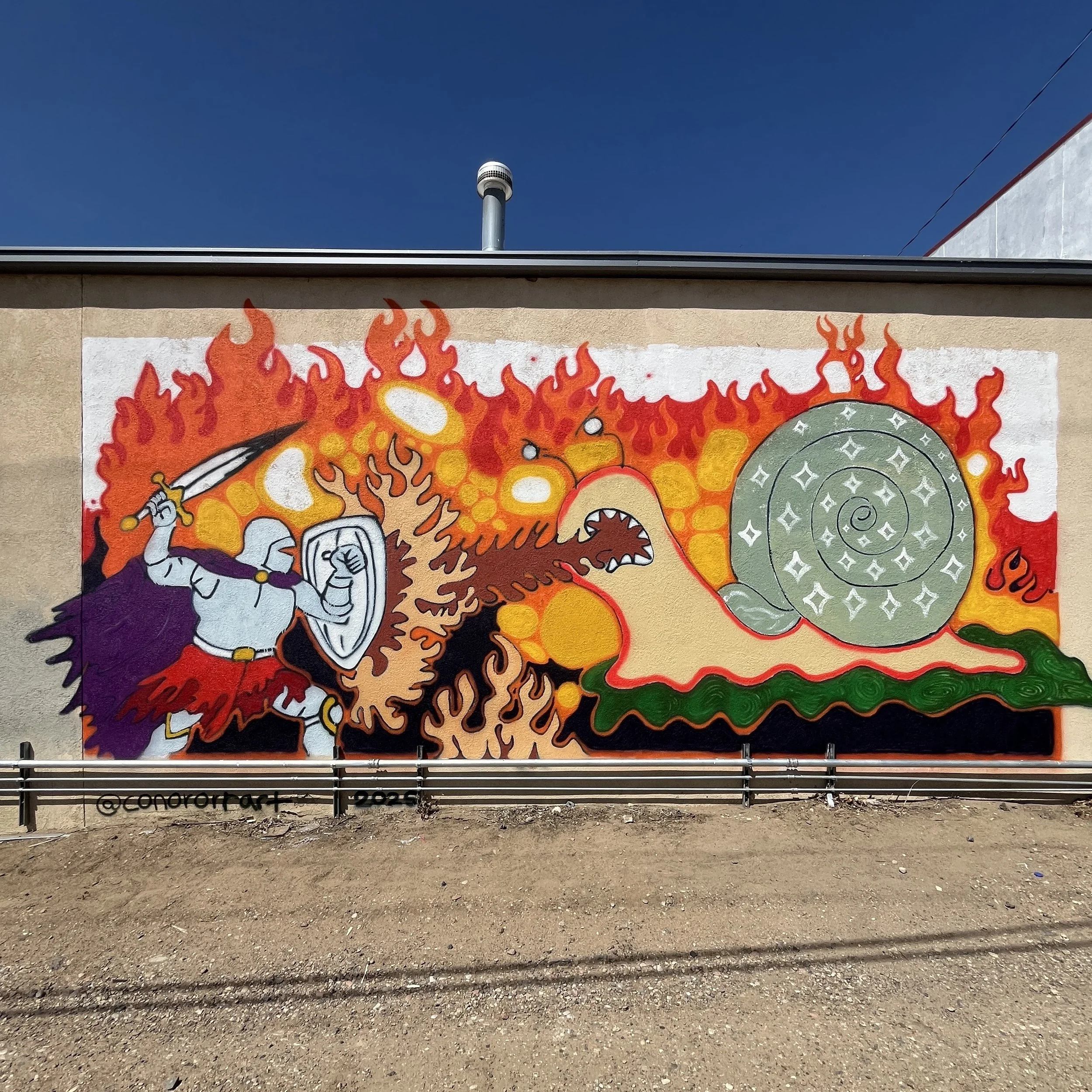 "Knight Fights a Fire-Breathing Snail!" (2025)

Painted for  Walsenburg Porchfest 2025

Located in the alley behind the Huerfano Fire Protection District Station One in Walsenburg