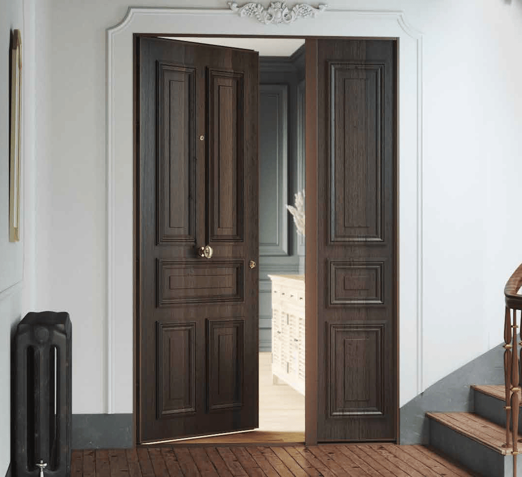 Une porte double en bois ouvrant sur une pièce intérieure décorée avec un cadre white au-dessus, à côté d'un escalier et d'un radiateur noir.