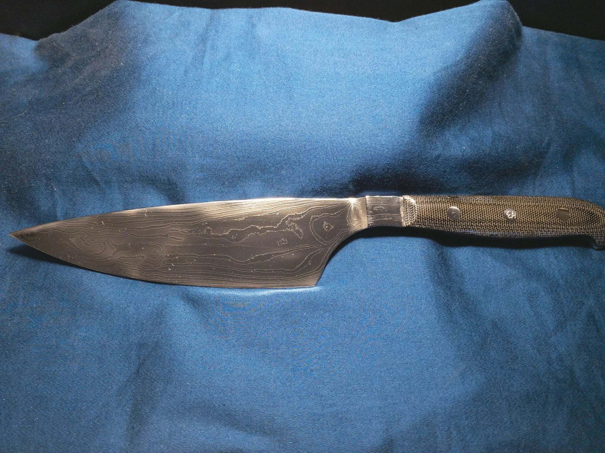 Chef's knife, made as a gift. (2021)
Blade: Laminated 5160 and 15N20 with integral bolster.
Handle: Full tang construction with canvas micarta scales.