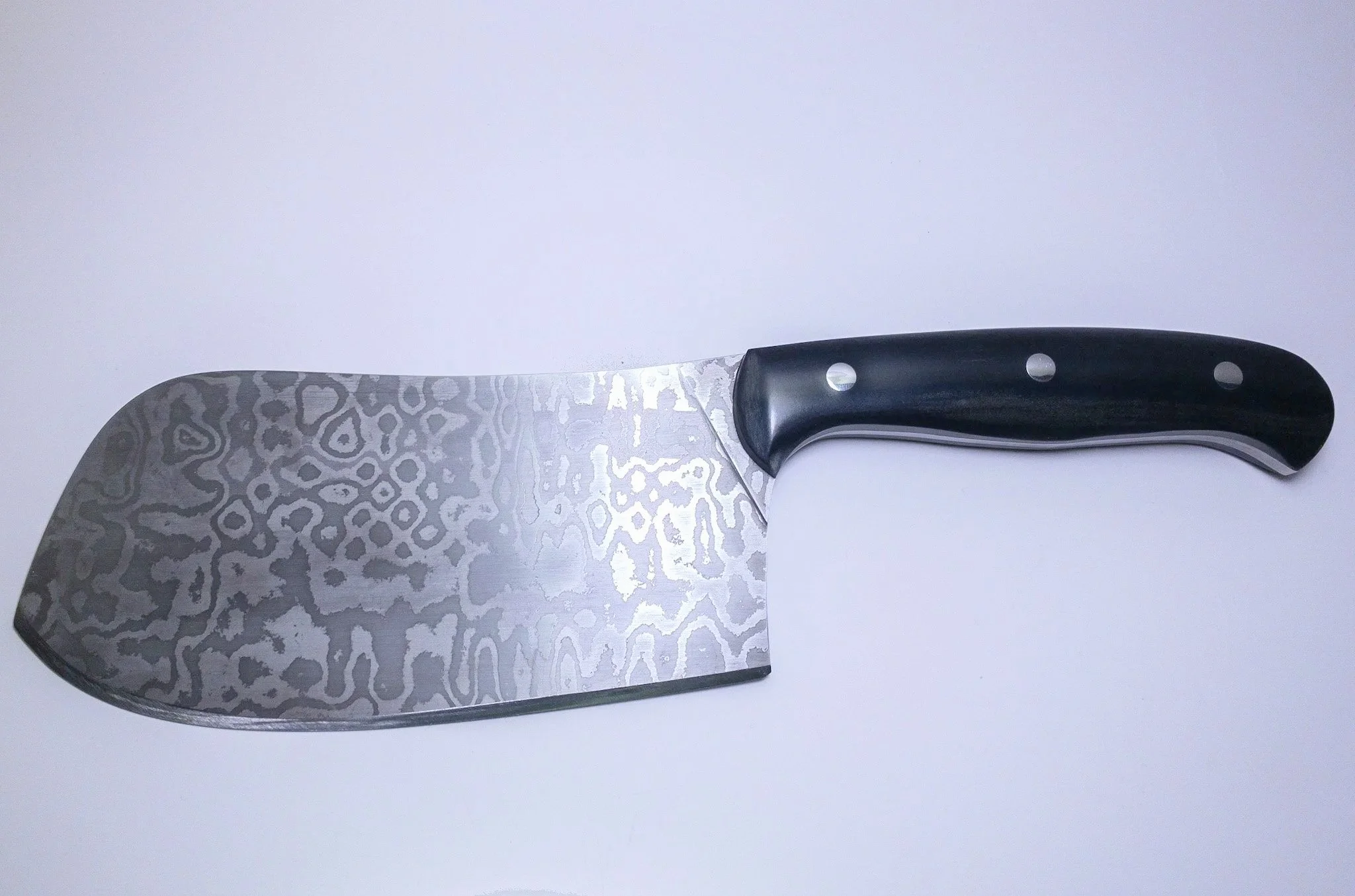 Commissioned cleaver for a cook in the SIU dining hall kitchen. (2021)
Blade: Laminated 5160 and 15N20.
Handle: Full tang construction with black paper micarta scales.
