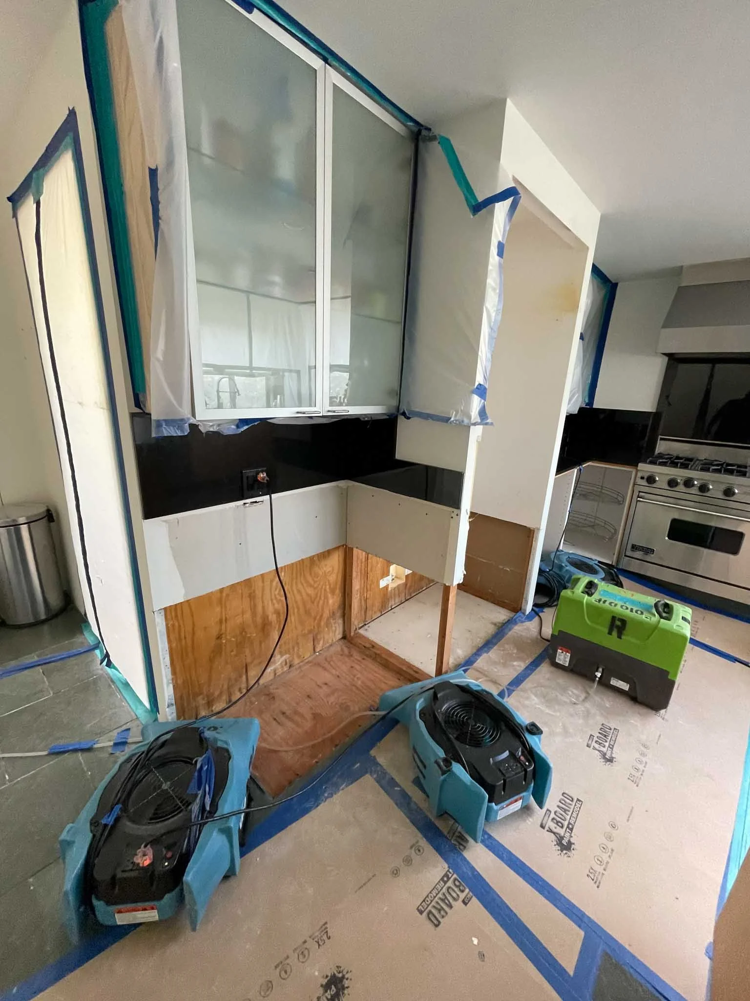 Kitchen under renovation with partially installed cabinets and tools on the floor.