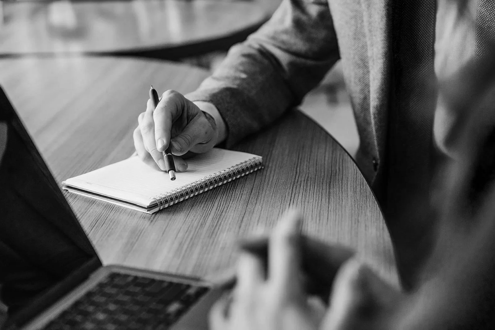 Executive coach documenting insights during professional leadership development session