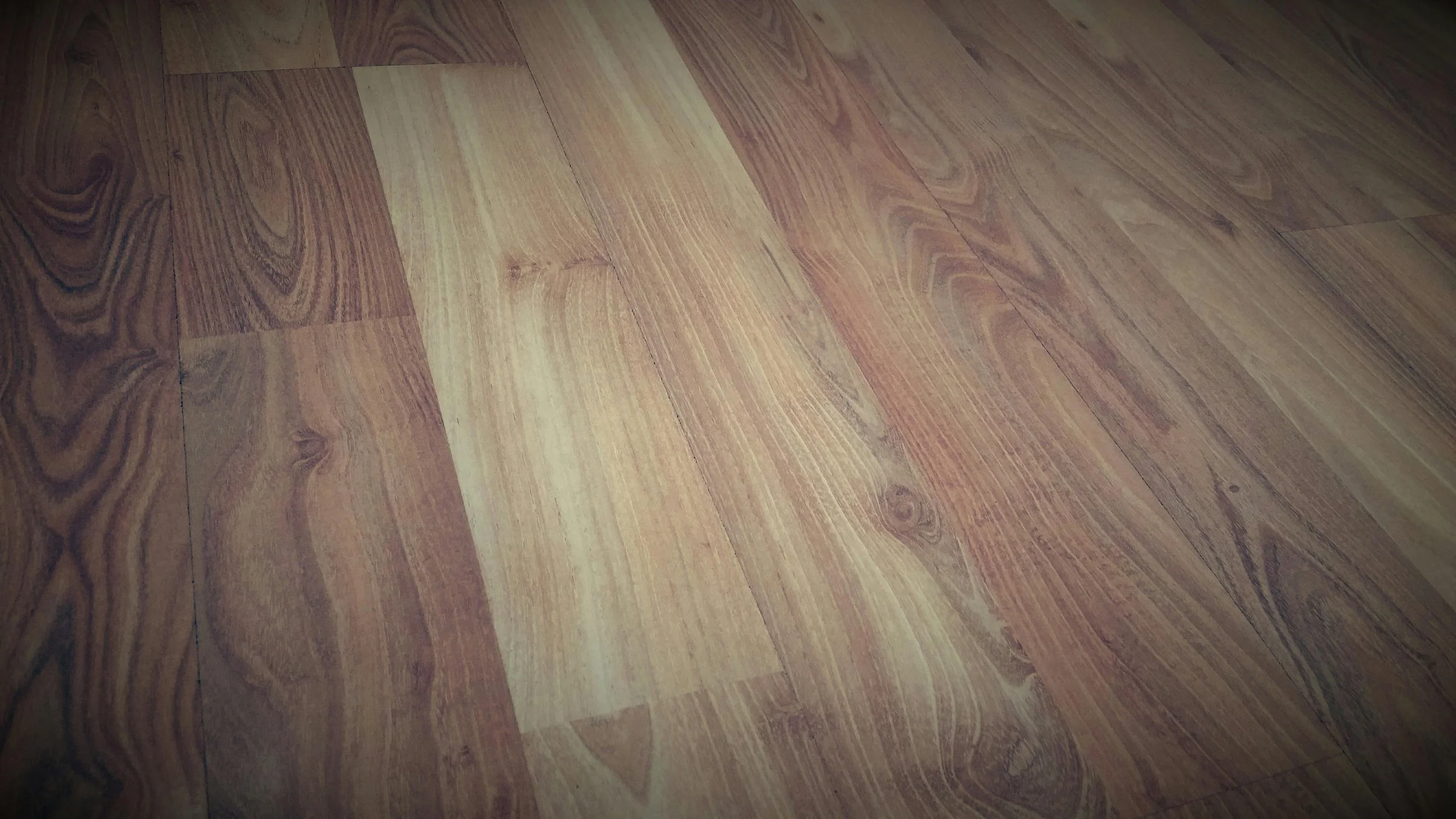 Close-up of a wooden floor with a pattern of natural wood grains and colors.