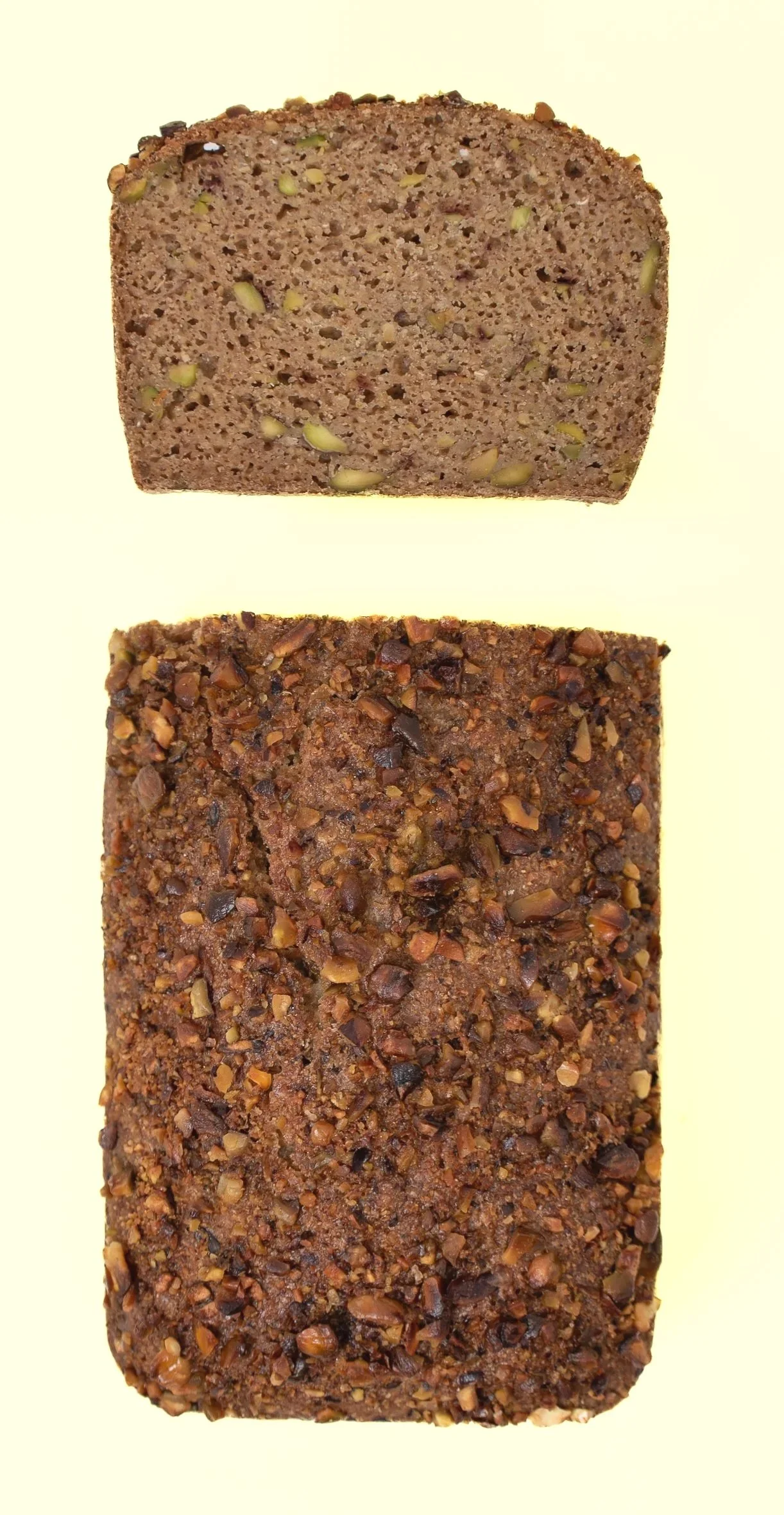 Two slices of banana bread, one plain and the other topped with chopped nuts.