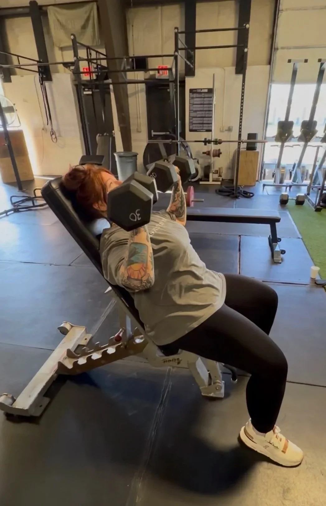 Next Level Coaching client Chelsea performing an incline dumbbell press during a personalized strength training session.