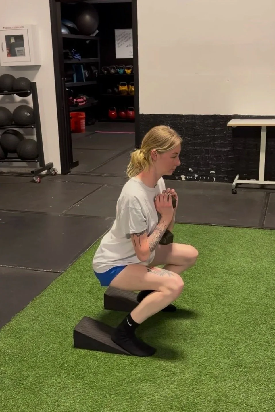 Next Level Coaching client Erica performing a weighted goblet squat during a personalized strength training session.