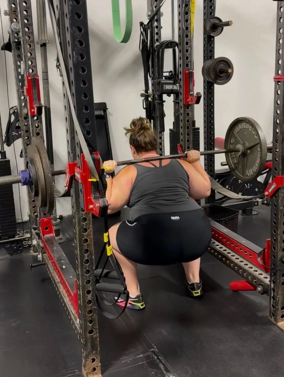 Next Level Coaching client Rachel performing a barbell squat during a personalized strength training session.