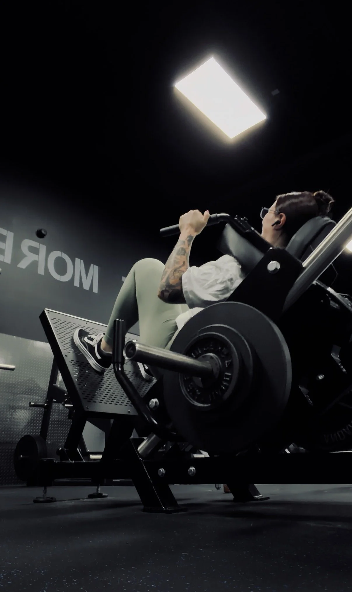 Natalie, Certified Personal Trainer at Next Level Coaching, performing a hack squat during strength training.
