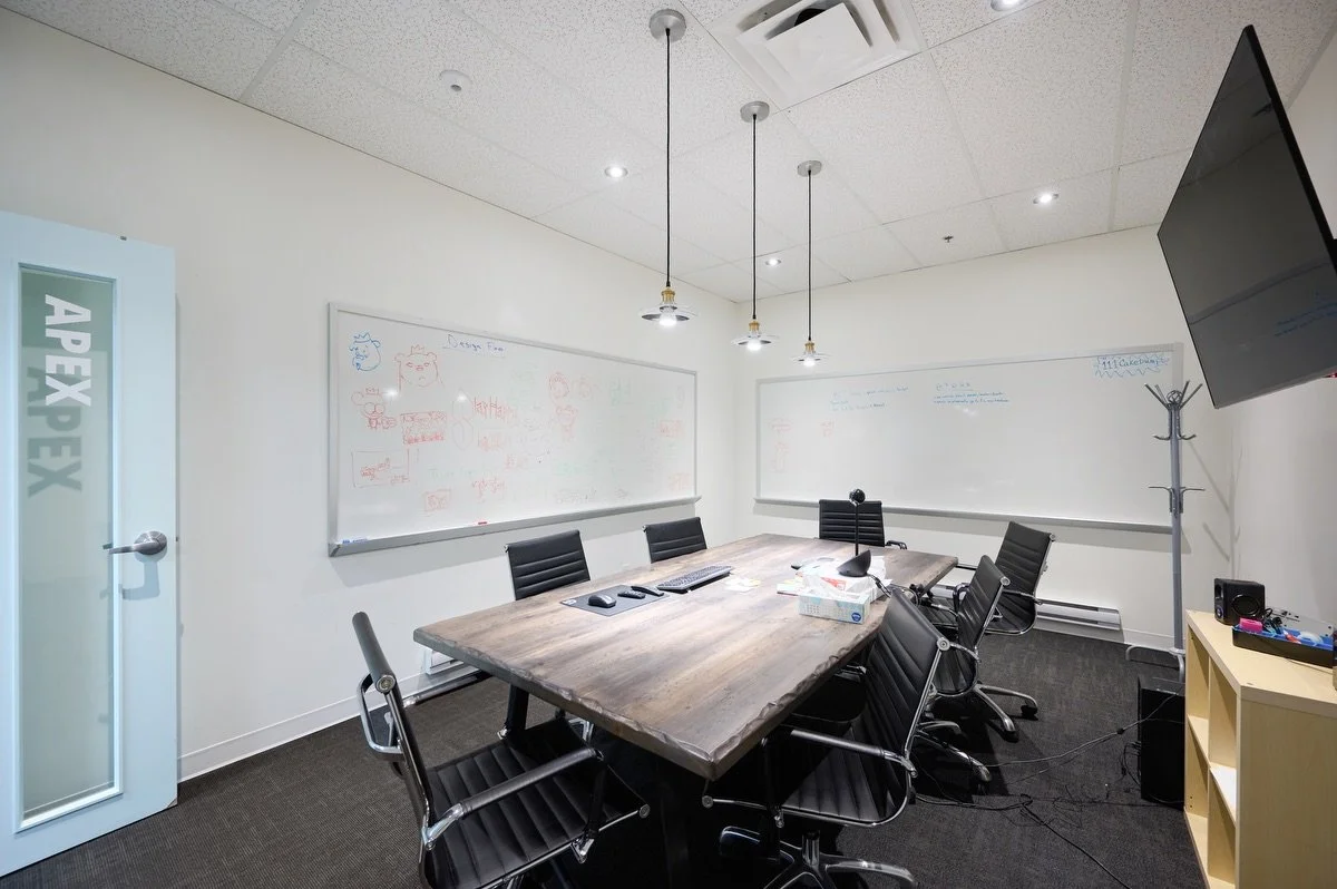 A North House meeting room with a large table, whiteboards and a screen