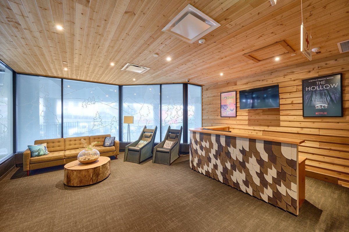 The sunlit North House Vancouver lounge, with cedar walls, a yellow sofa and places to sit together