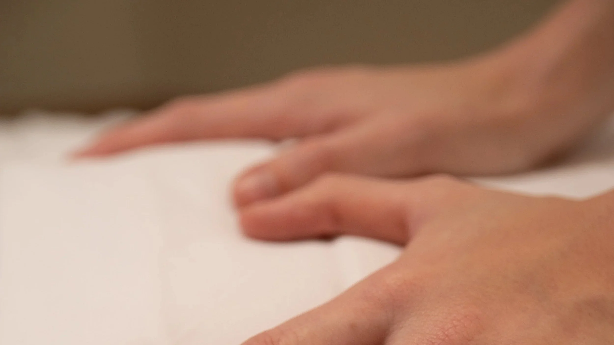Hands on a white sheet massaging a client.