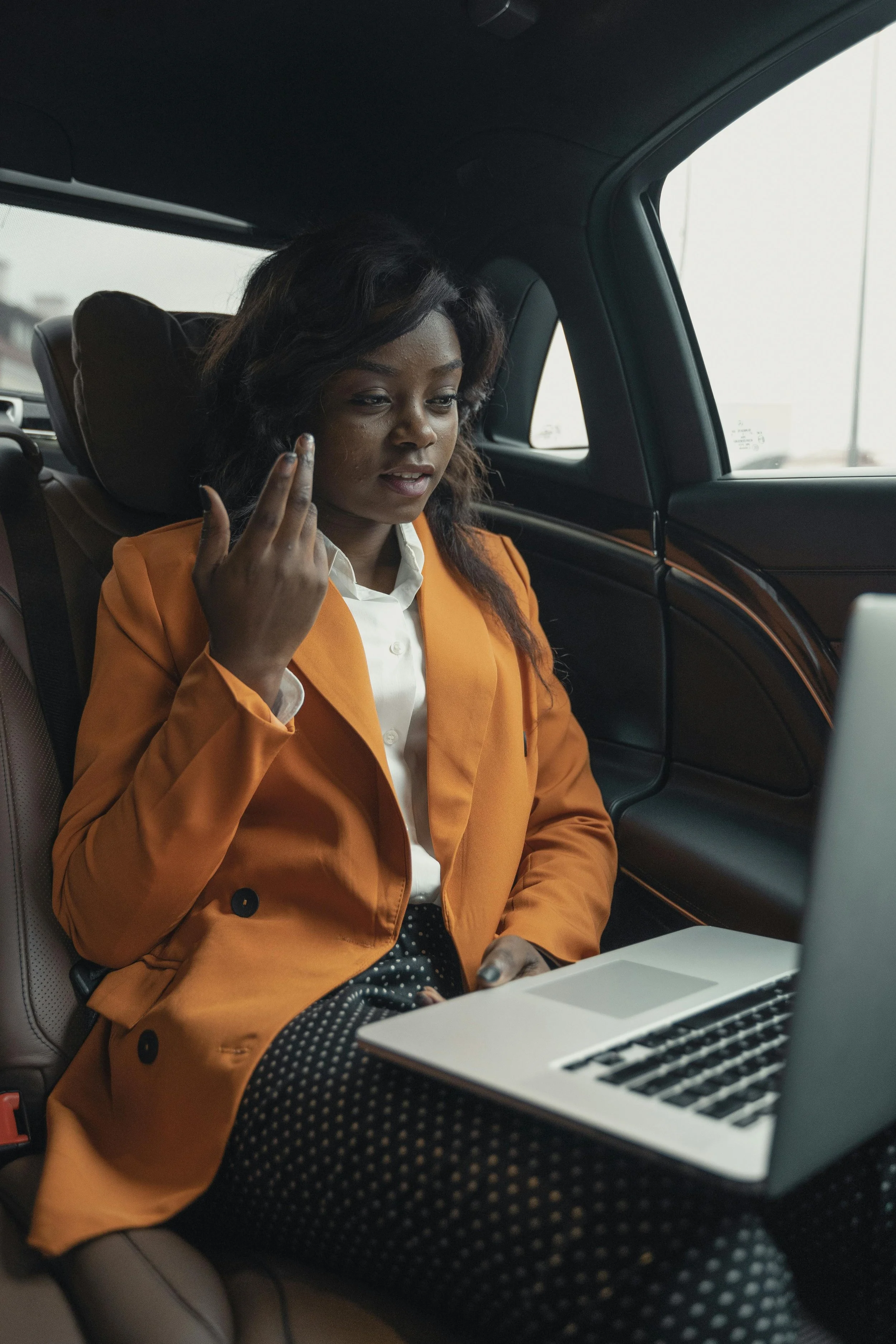 Professional woman working while riding in a car, representing trauma therapy support for high-functioning adults