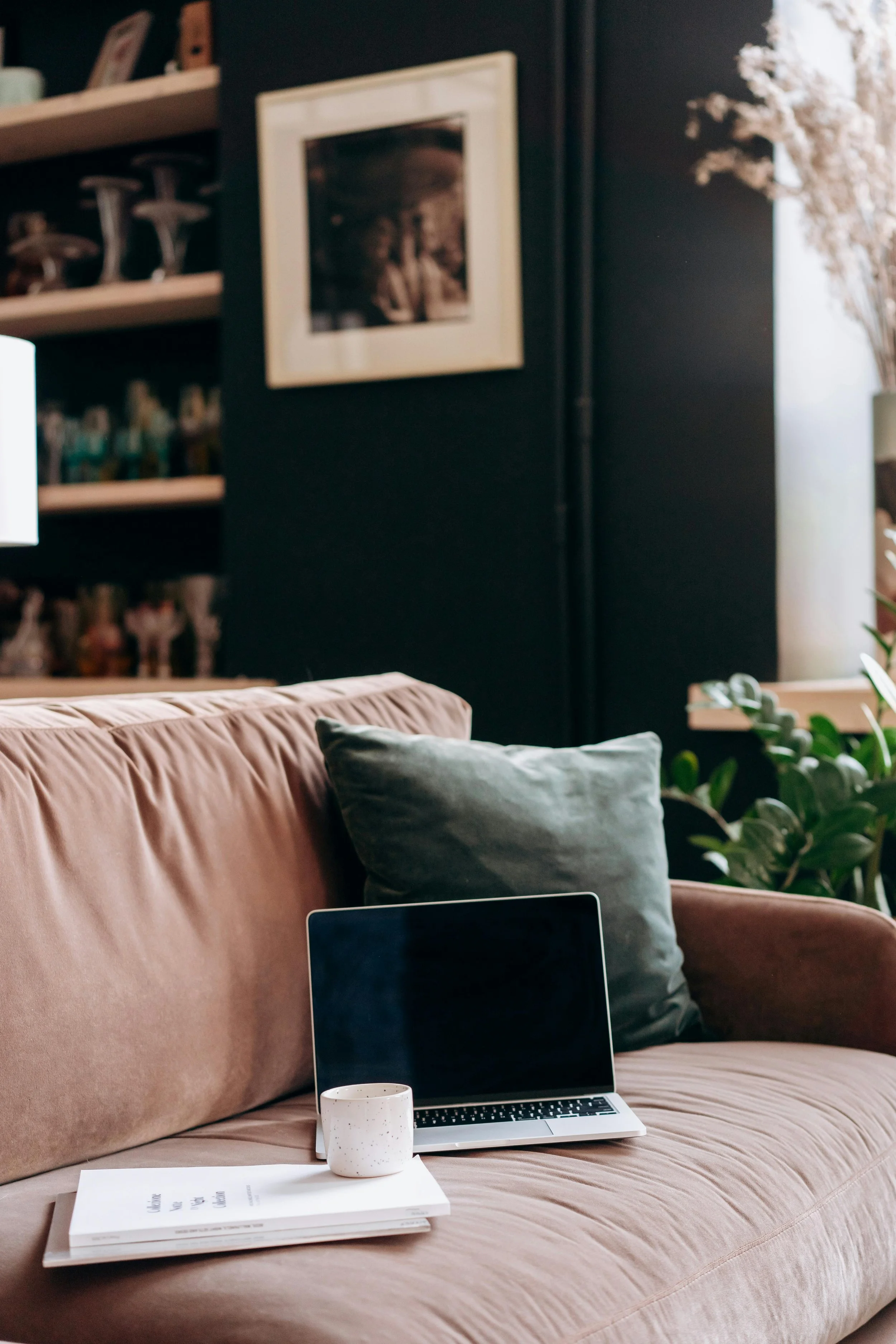 Open laptop on a couch with a notebook and mug, representing burnout support for professionals and leaders