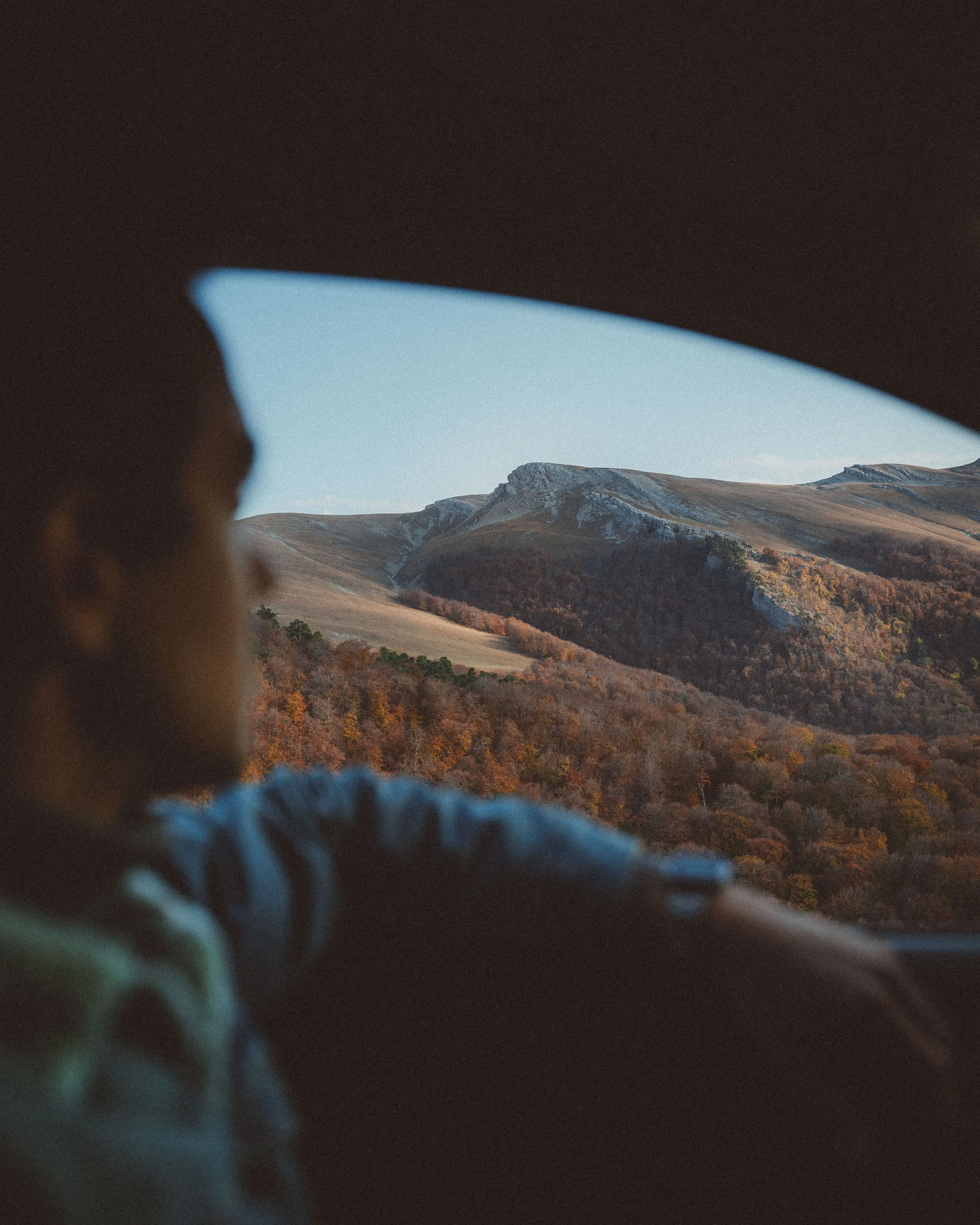 Mountains viewed through an opening with a person in the foreground.