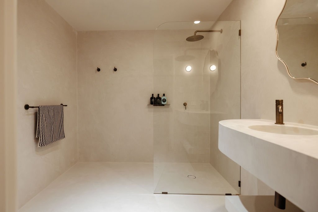 A spacious walk-in bathroom featuring handcrafted finishes and calming tones to begin and end your day.