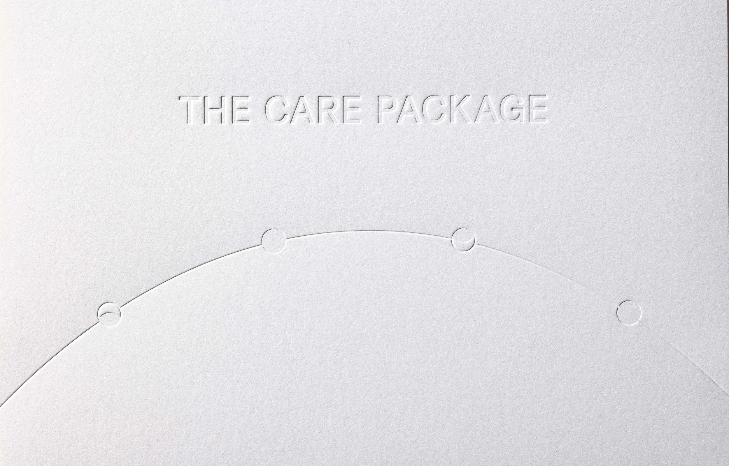White card with embossed text 'The Care Package' and a curved line with four embossed circles.