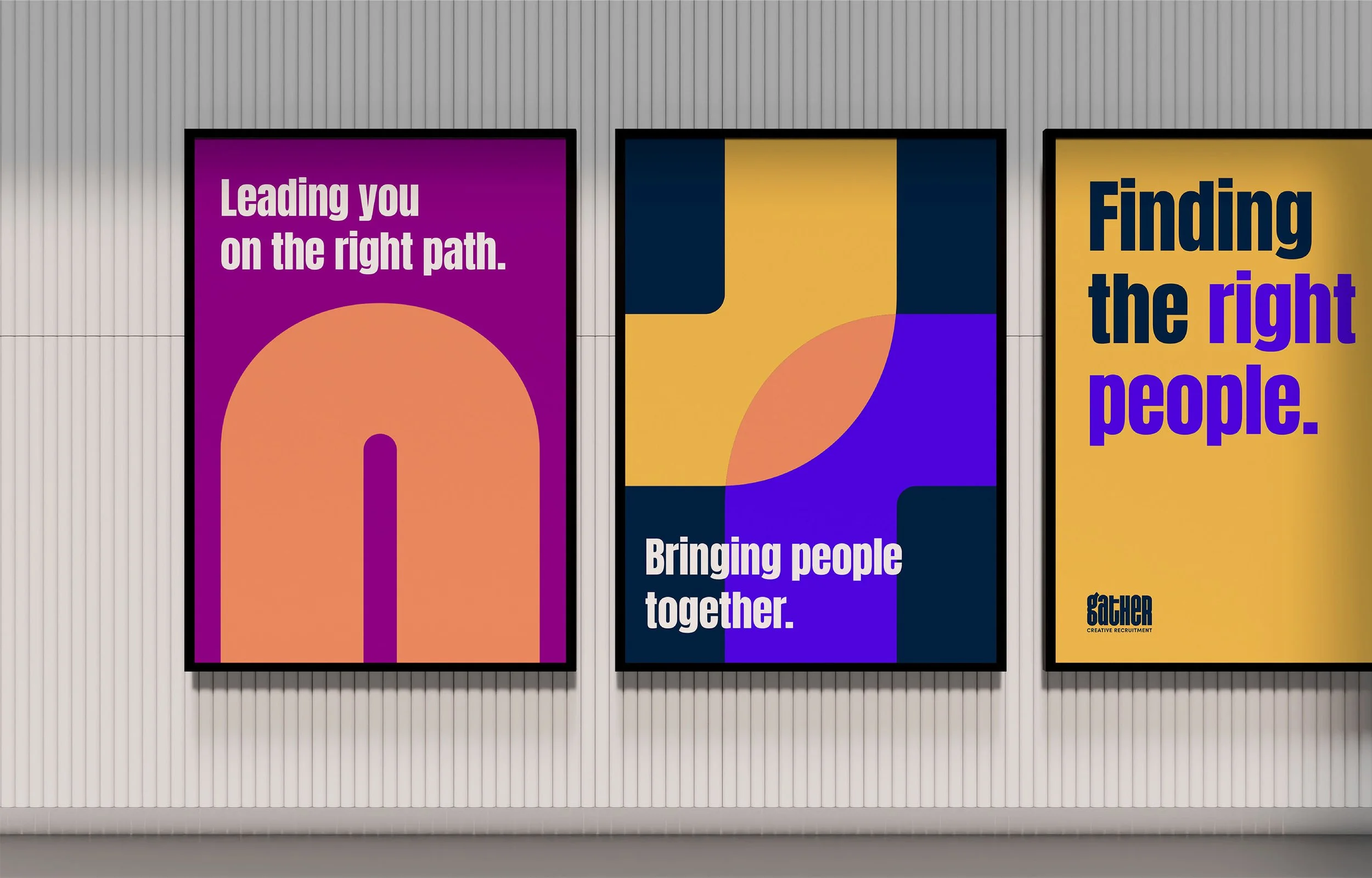 Three colorful promotional posters on a wall with vertical lines. The first poster says "Leading you on the right path." with a large orange arrow pointing down. The second poster features abstract shapes in yellow, blue, and purple with the text "Bringing people together." The third poster has a yellow background with the text "Finding the right people." and a small logo at the bottom left that says "Gather Creative Recruitment."
