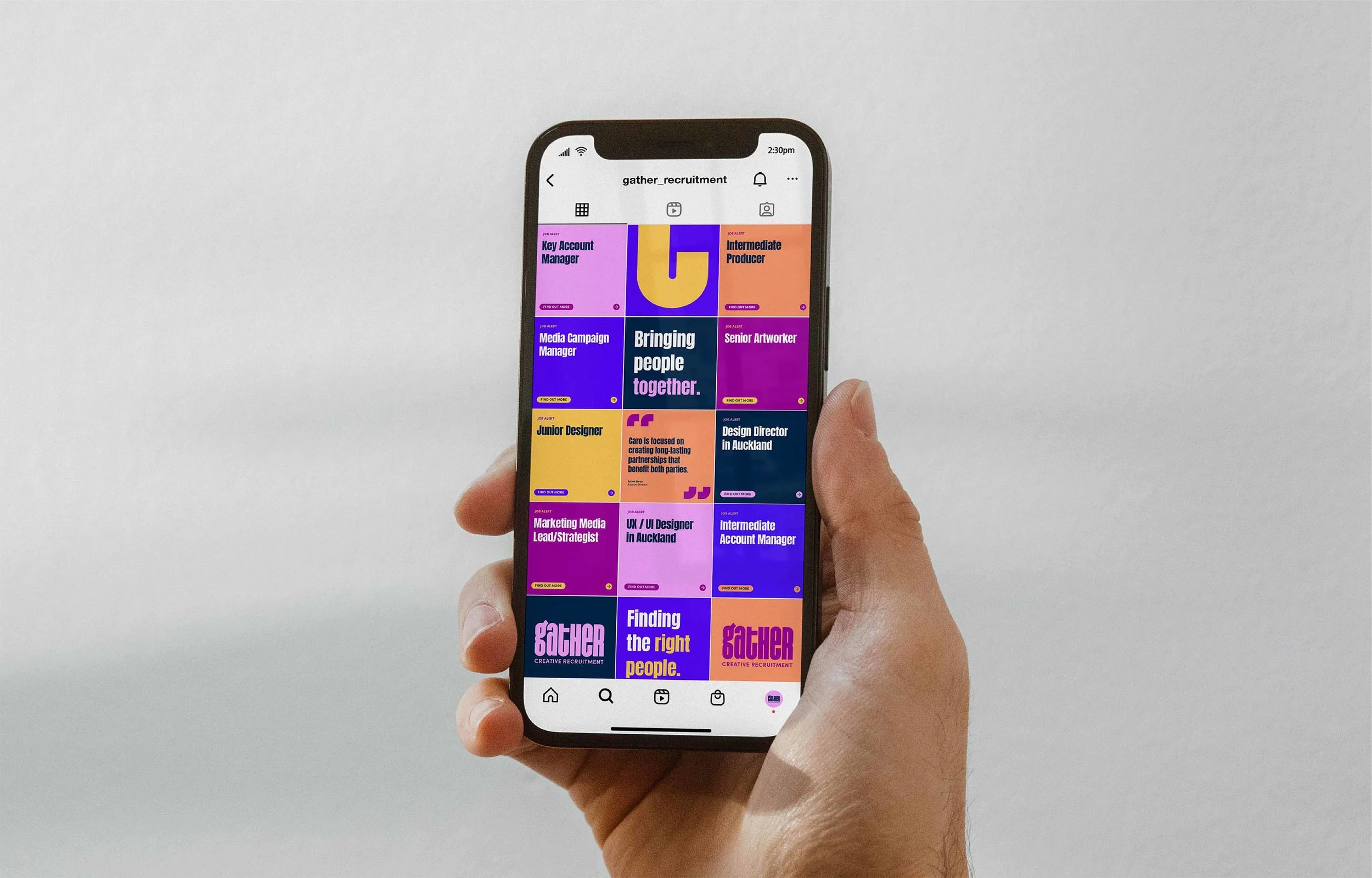 A person holding a smartphone displaying an Instagram profile with various colorful recruitment-related posts.