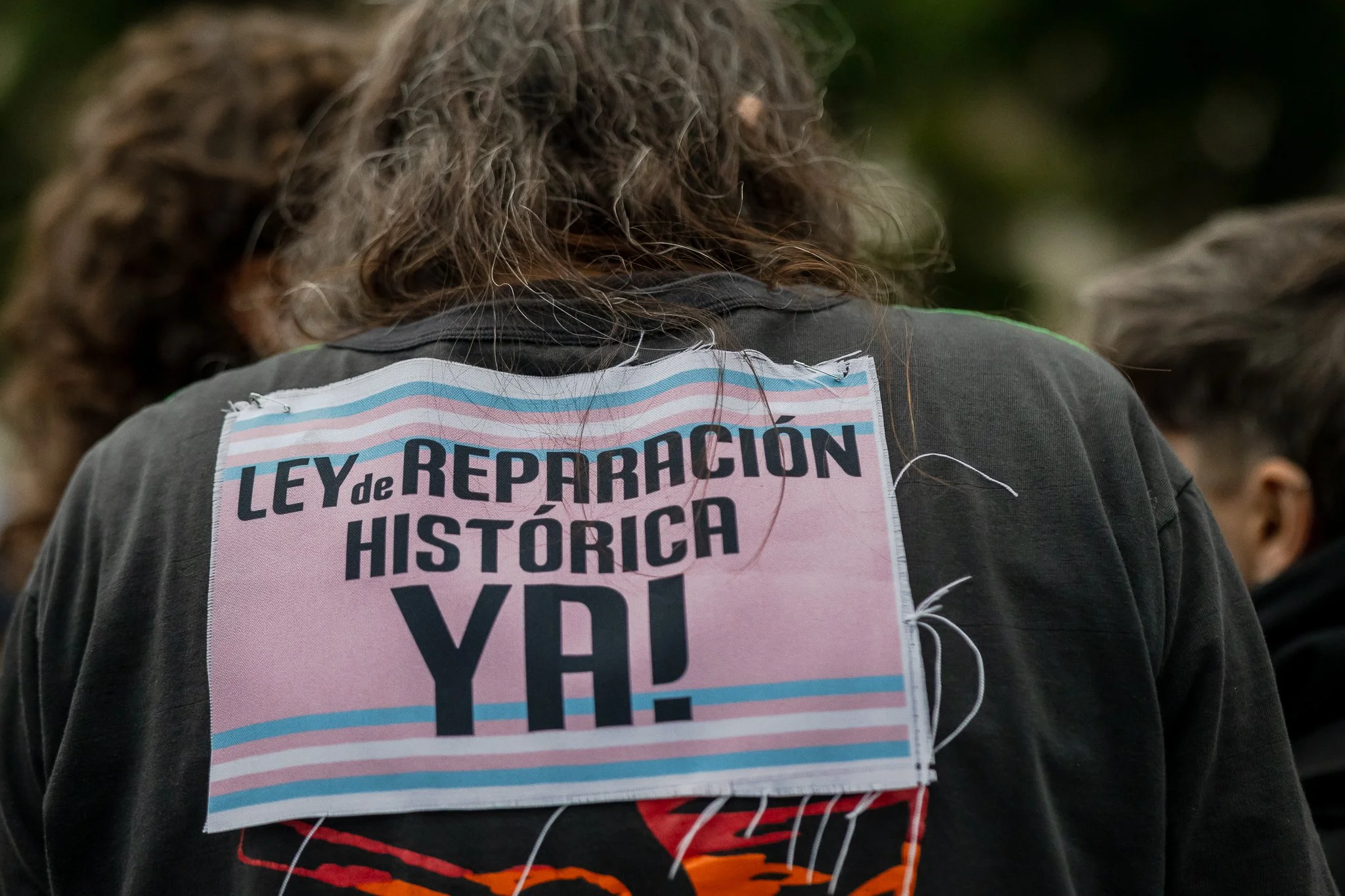 Persona con una campera con texto que dice 'Ley de Reparación Histórica'.