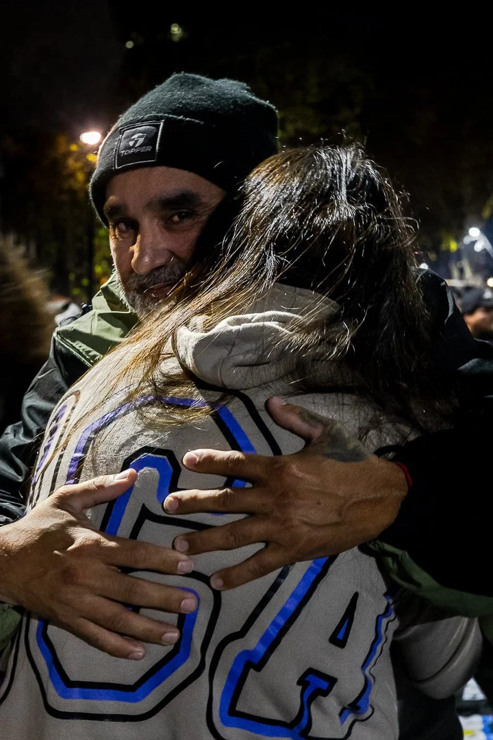 Dos personas abrazándose en la calle por la noche, expresando afecto.