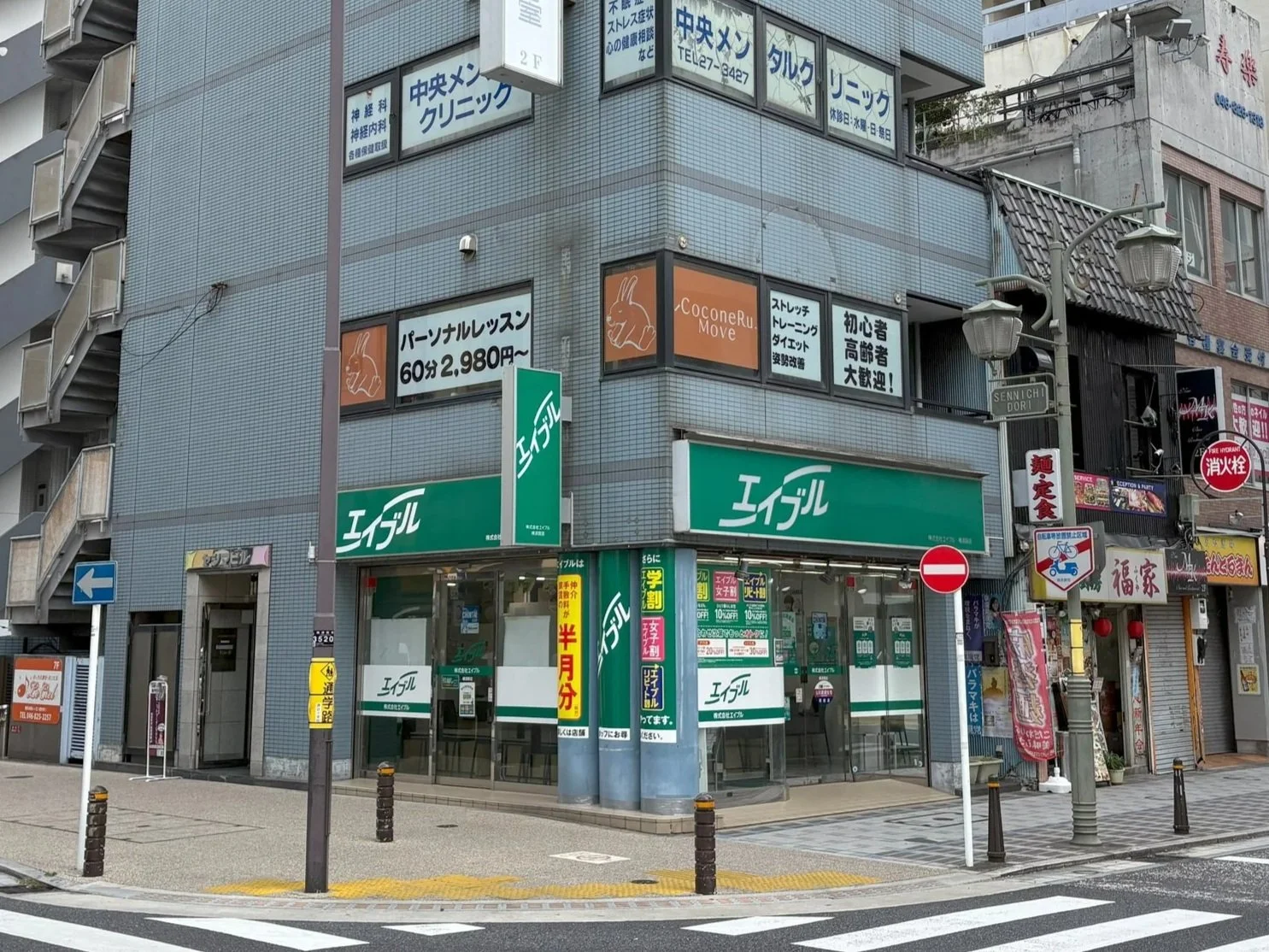 実店舗の外観と、周辺の看板や信号機、道路標識。