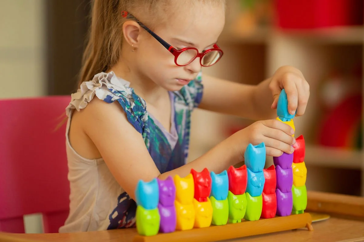 Young girl with down syndrome playing with a colourful puzzle