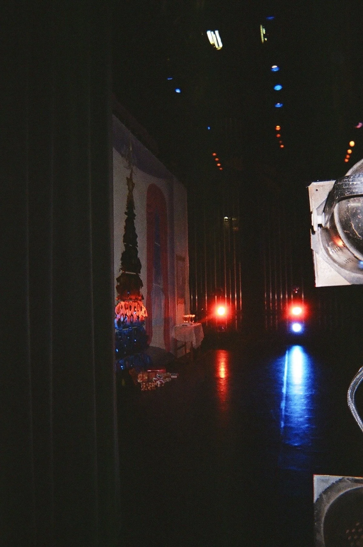Elana Kline Art Photography: Dark room with a decorated altar or stage on the left, red and blue stage lights, and a disco ball hanging from the ceiling.