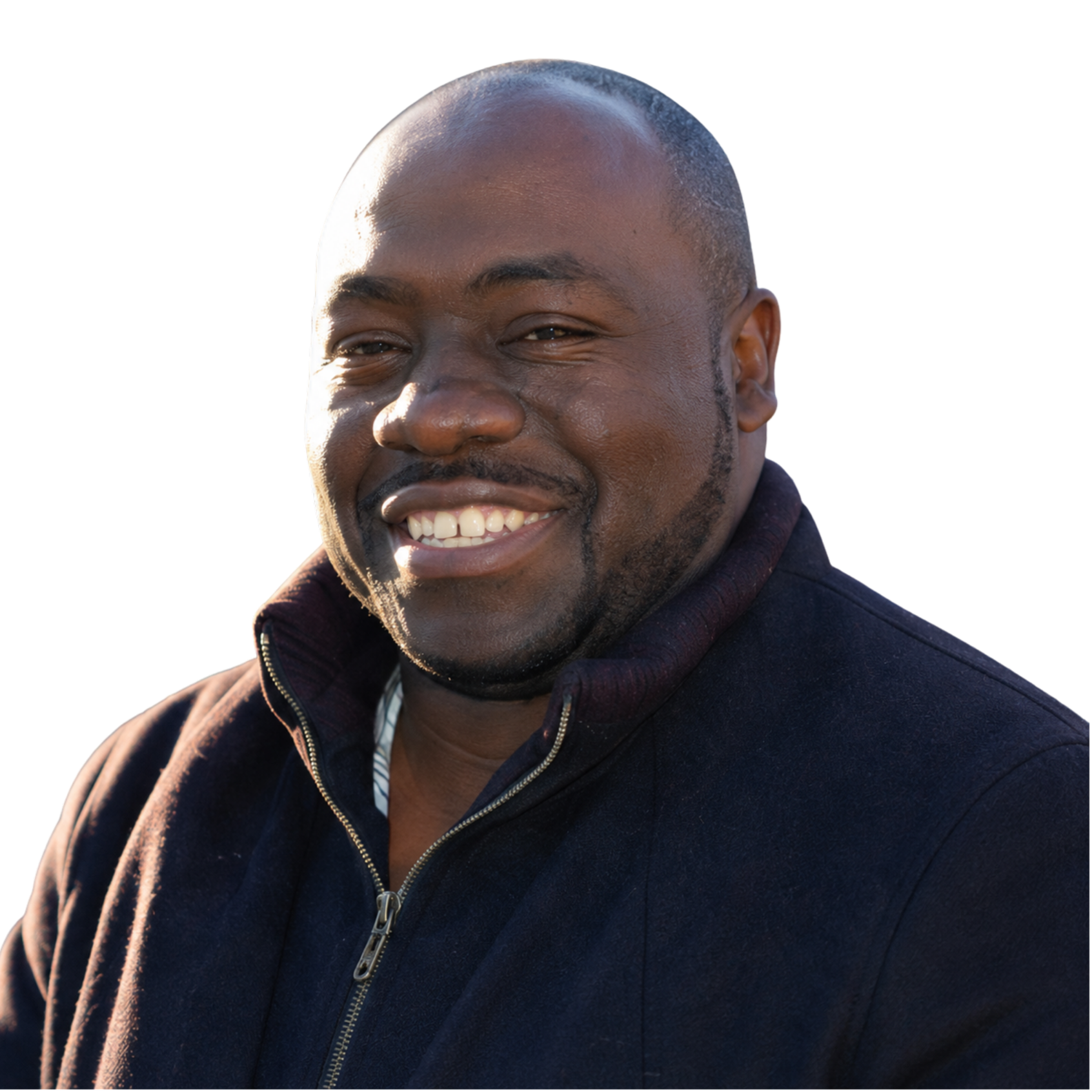 Close-up of a smiling African American man with short hair, wearing a dark jacket with a zipper, outdoors during daytime.