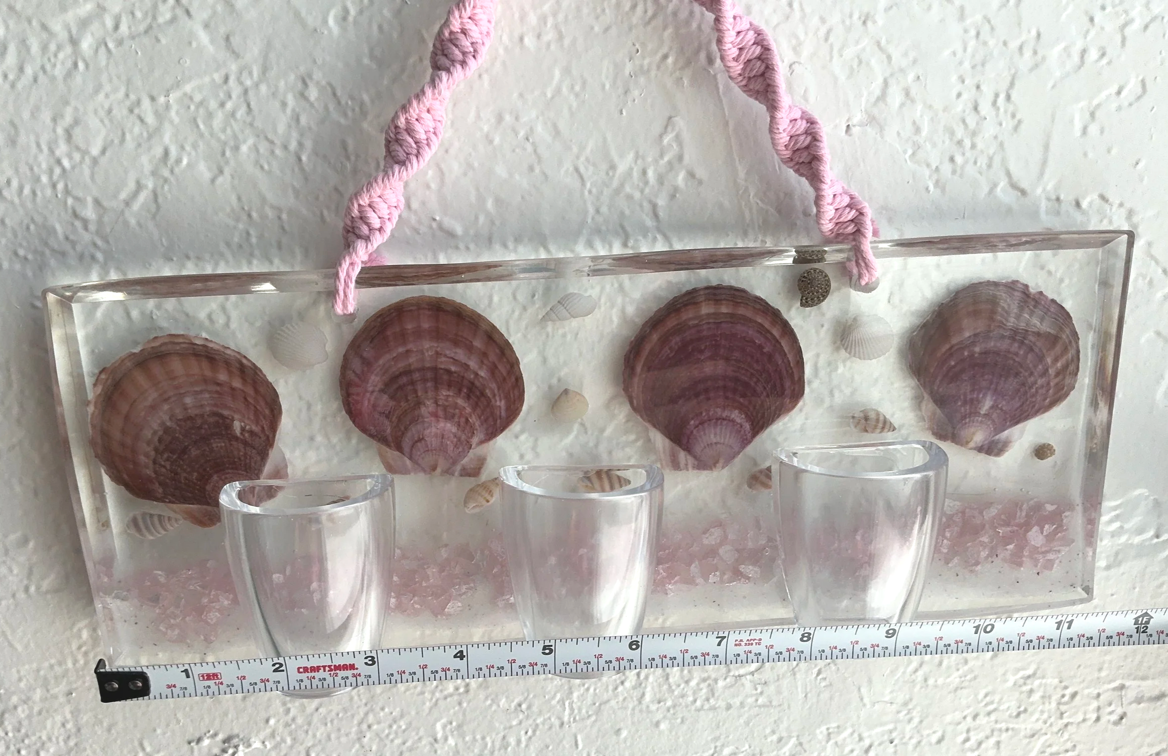 Front view of handmade shell resin wall planter with measuring tape across the rectangular panel to show its approximate width.