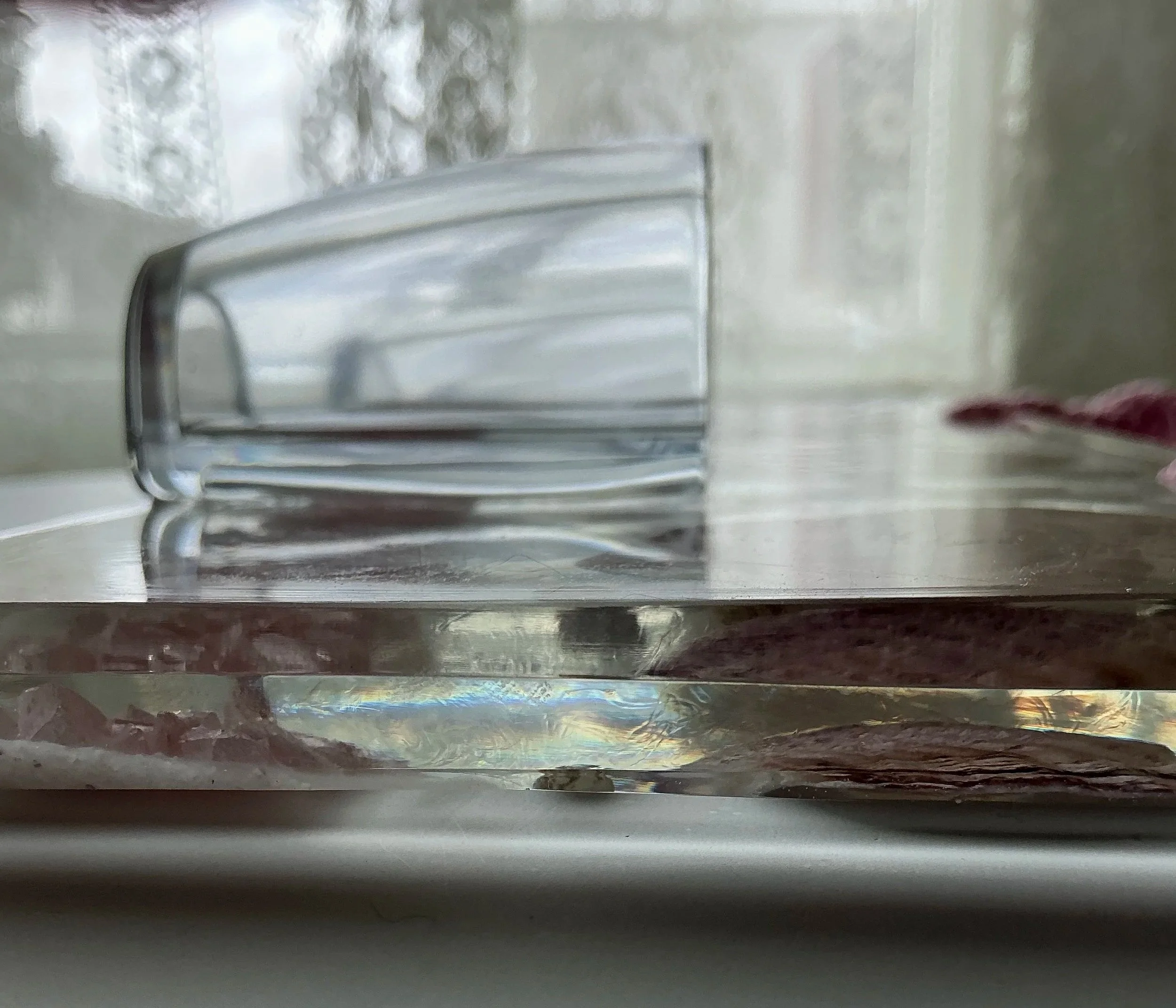 Low side view of the clear resin panel and transparent end of the vessel showing the thickness, depth and dimensional construction of the handmade wall planter.