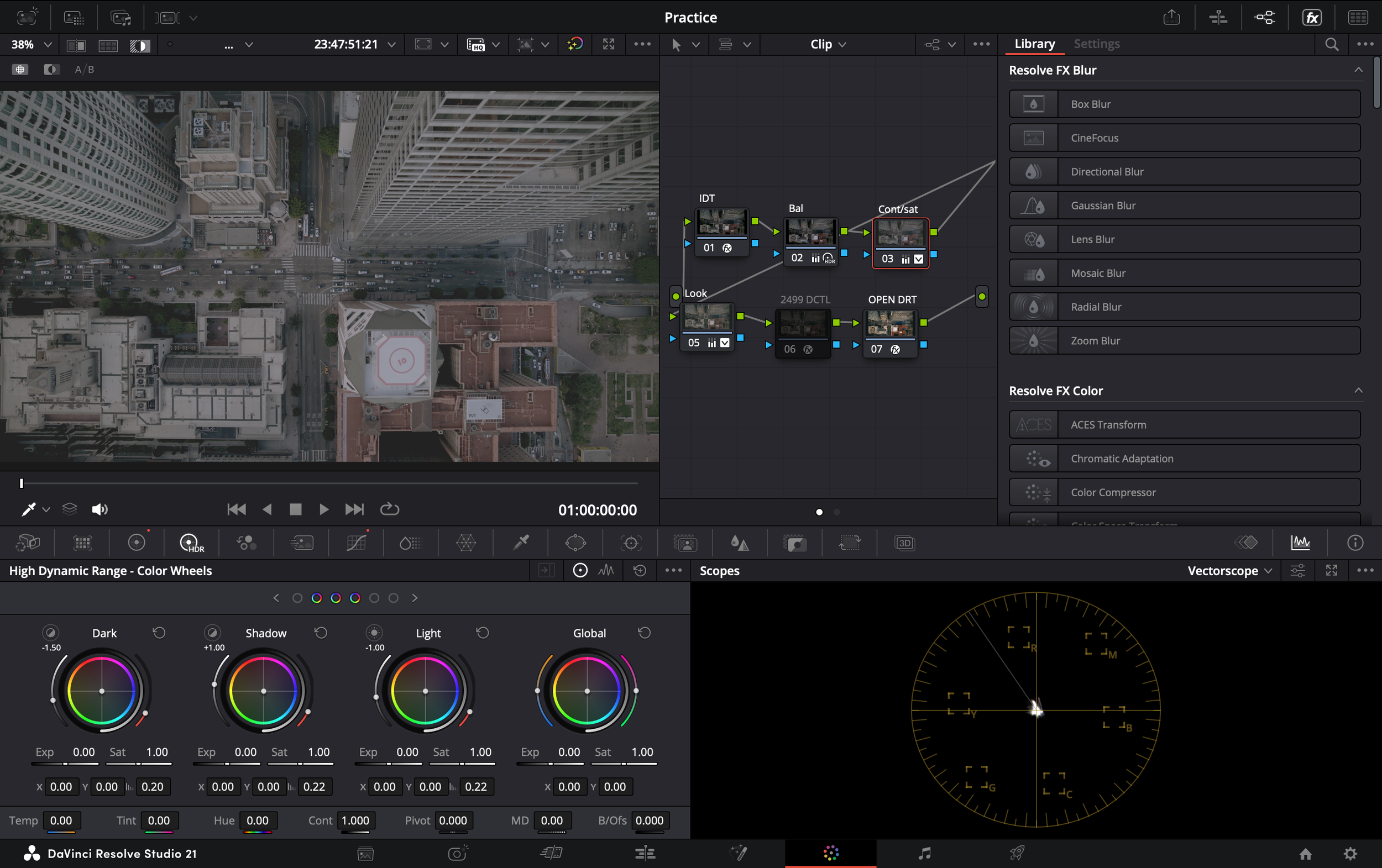 Screenshot of DaVinci Resolve Studio 21 video editing software showing a video clip of an aerial view of city buildings and streets with traffic. The interface displays color correction tools and effects.