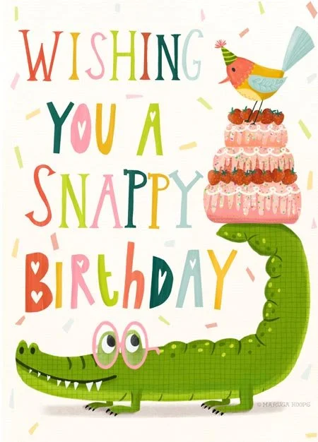 Colorful birthday card with a smiling crocodile wearing glasses, holding a three-tiered pink cake with strawberries and a bird on top, and the text "Wishing You a Snappy Birthday."