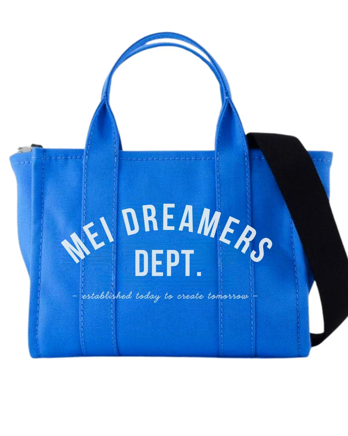 Blue tote bag with white text reading 'MEI DREAMERS DEPT.' and a smaller cursive slogan beneath.