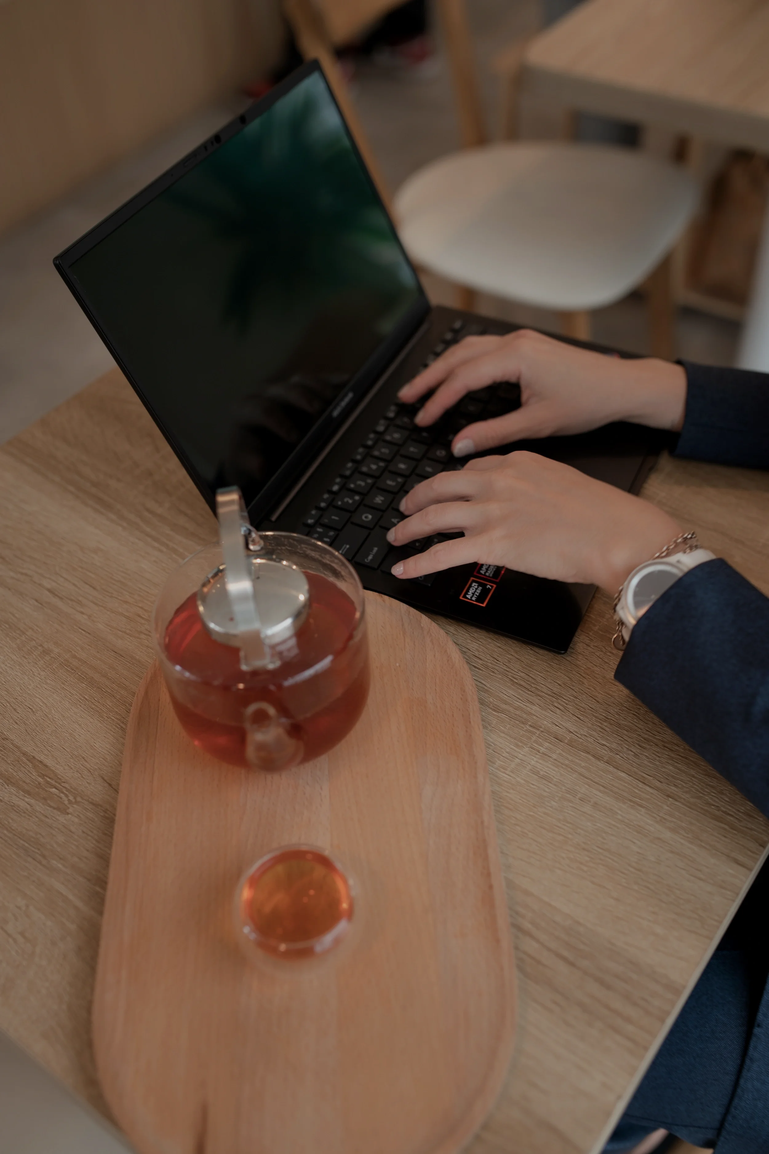 Markkinointiasiantuntija työskentelee kannettavalla tietokoneella kahvilassa – digitaalisen markkinoinnin ja strategisen sisällöntuotannon suunnittelua, VIMA Digital.