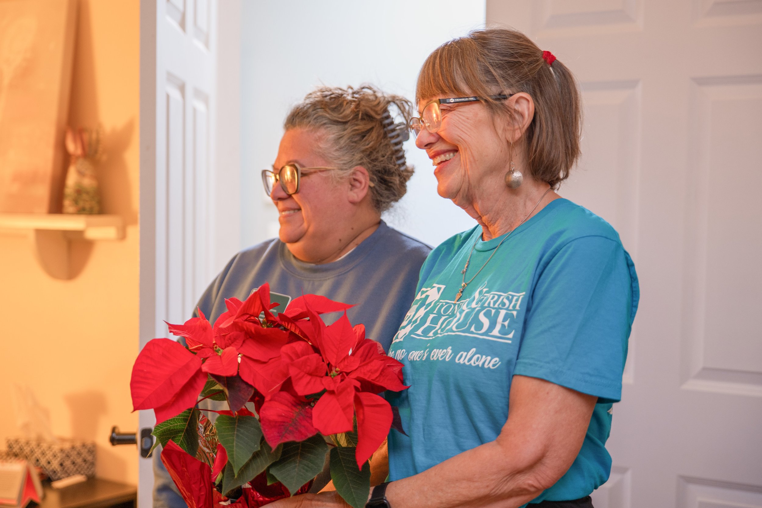 Two Toni & Trish House volunteers standing together smiling