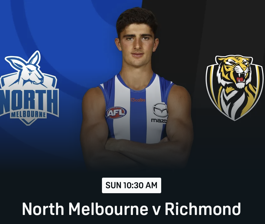 A young male athlete wearing a blue and white sleeveless sports jersey with logos, standing with arms crossed in front of a background featuring the North Melbourne Australian Football League team logo on the left and a tiger mascot logo on the right, with a scheduled game time of Sunday at 10:30 AM against Richmond.