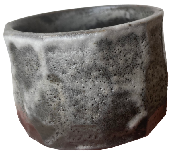 Organic cup made in black clay with white glaze running down