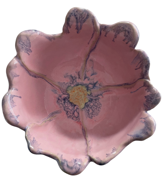 Close-up of a ceramic flower-shaped dish with pink petals and a yellow center.