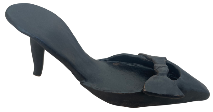 Sculpture of a high heel shoe in black with a bow on the front