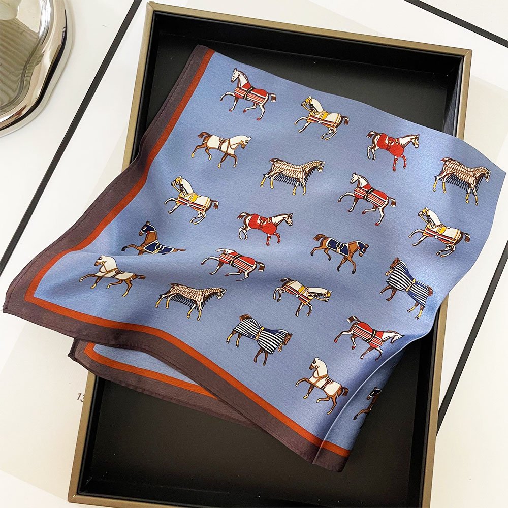 A cloth with a pattern of various horses in different colors and stripes, displayed inside a black box.