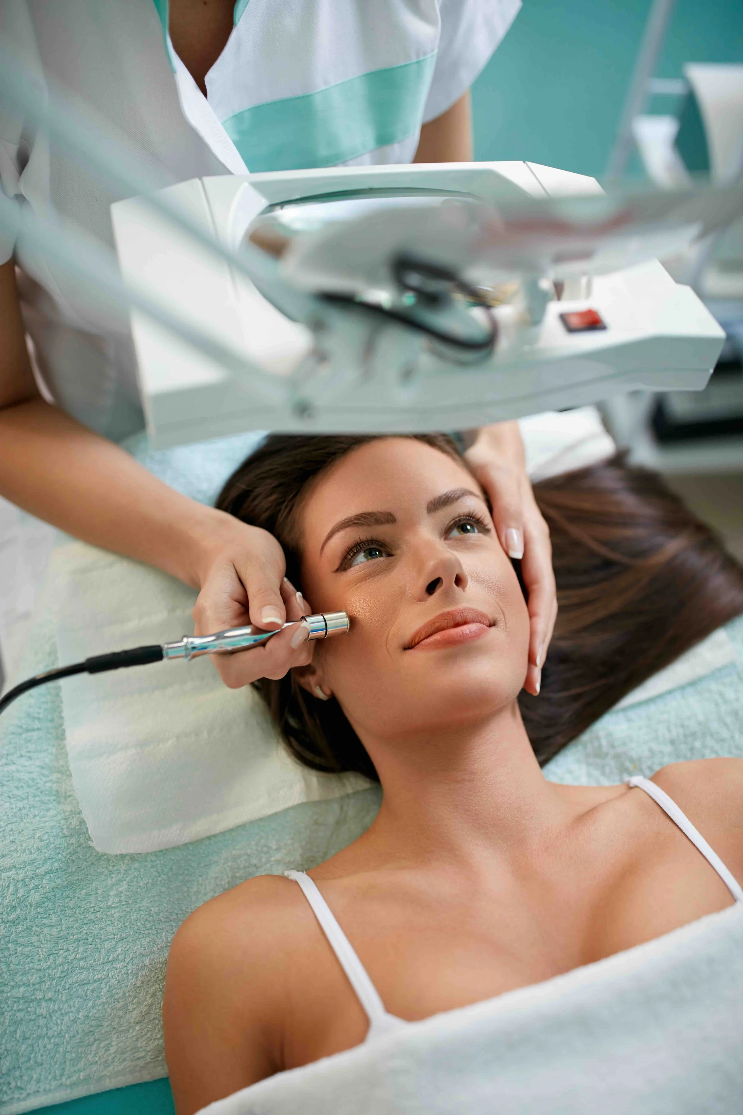 Frau erhält eine kosmetische Behandlung mit einem elektrischen Gerät im Studio.