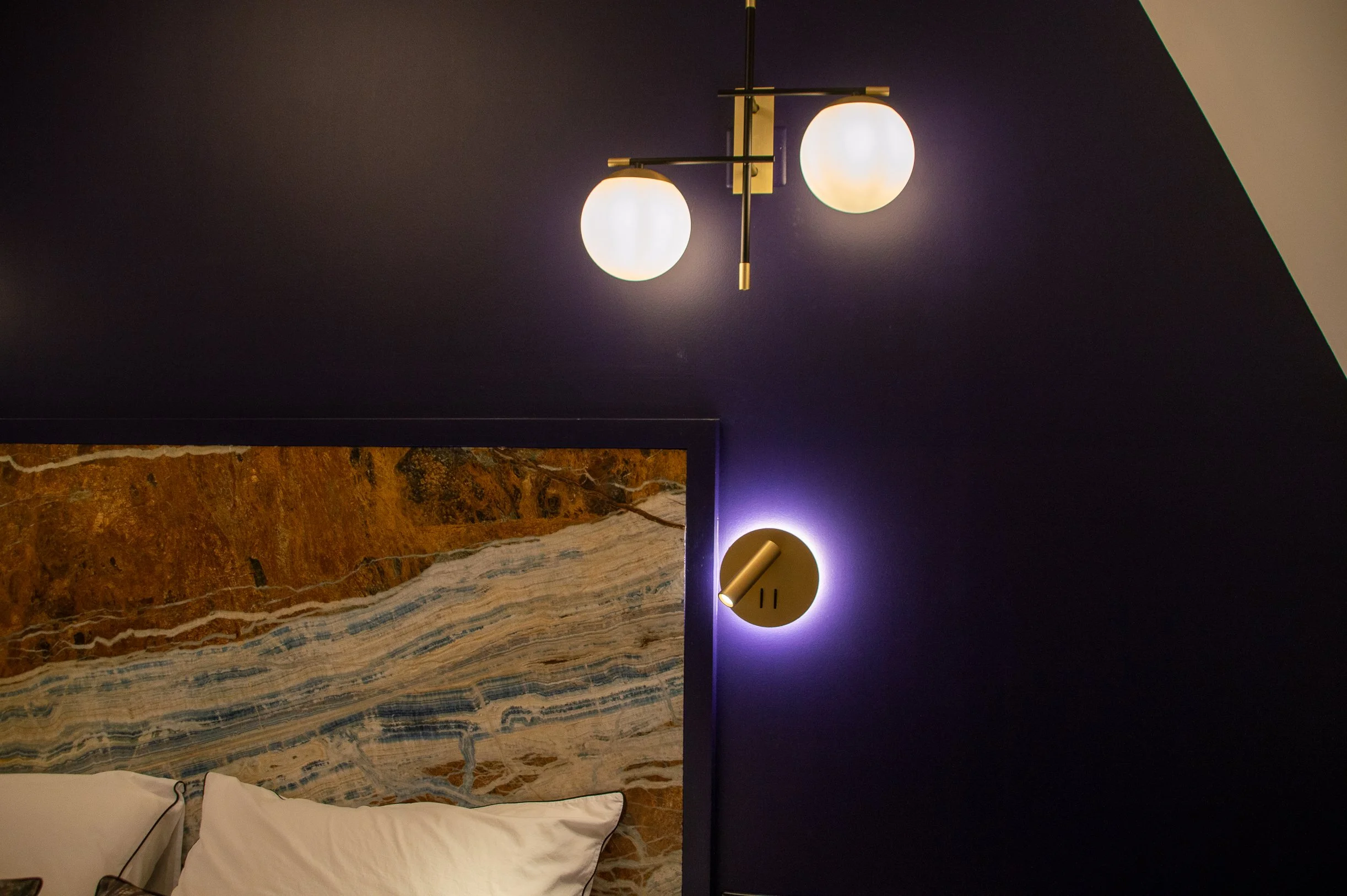 Éclairage moderne dans une chambre, featuring un plafonnier à deux globes et une lampe murale with lumière ambiante