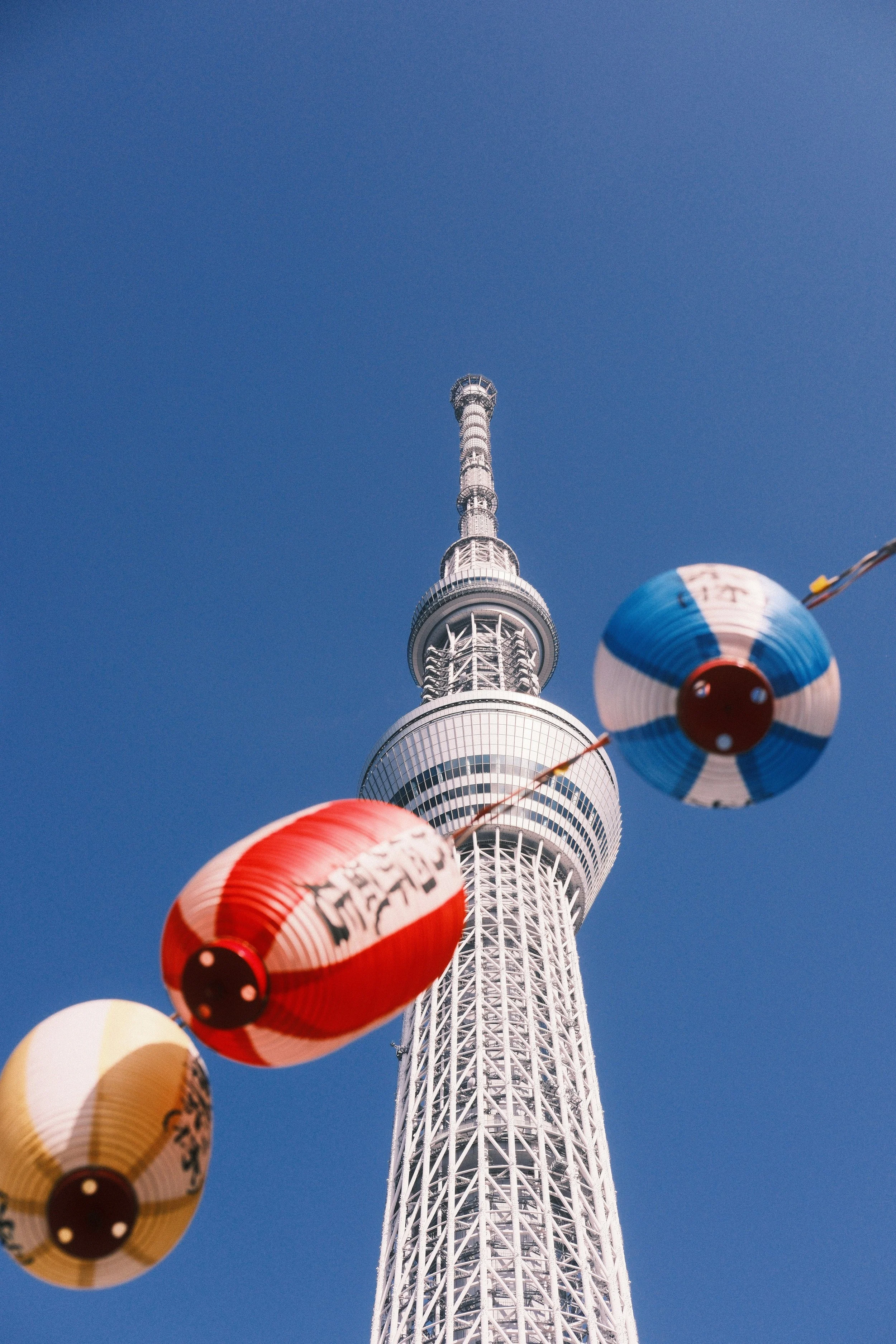Der Tokyo Tower vor klarem Himmel mit bunten japanischen Papierlaternen im Vordergrund