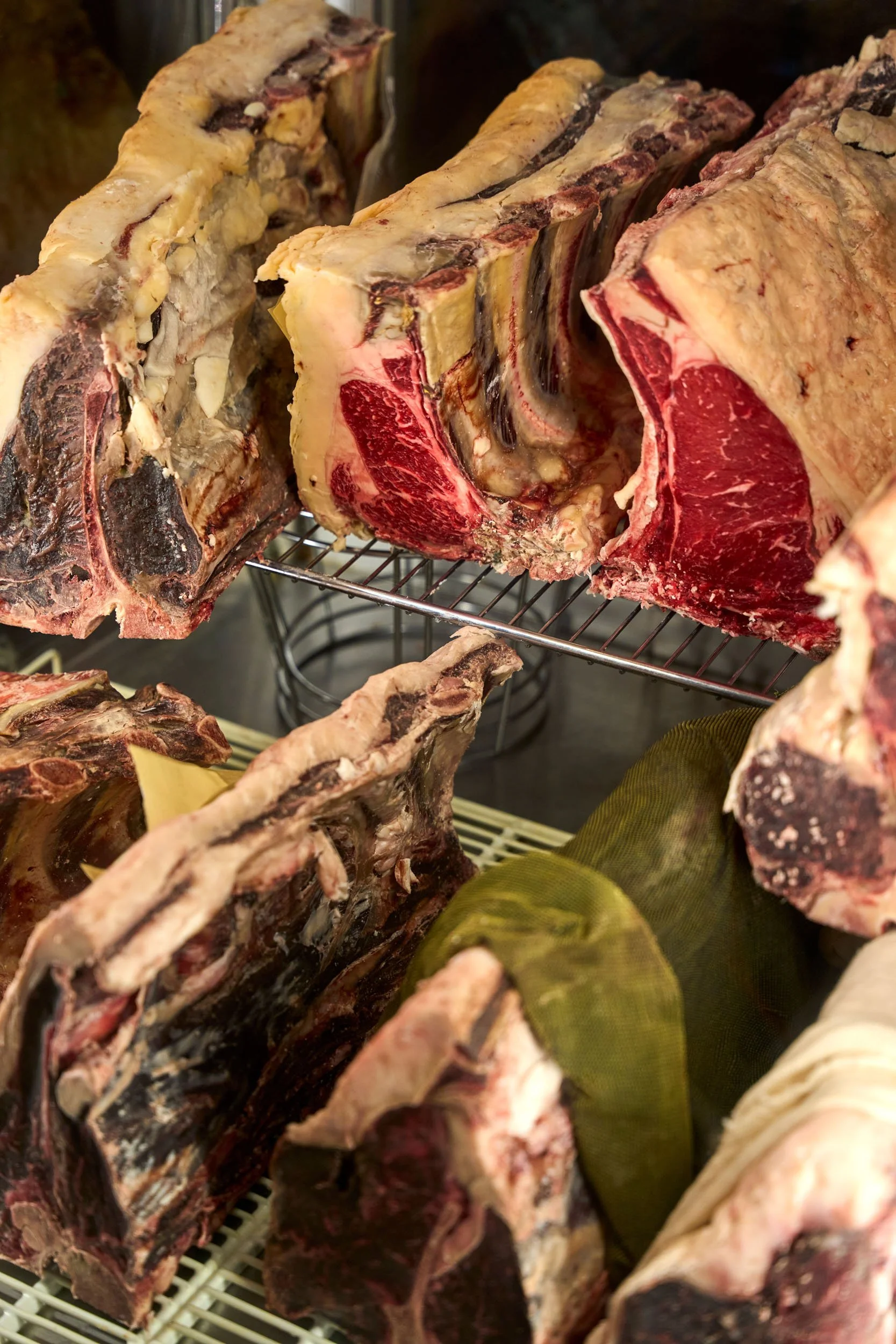 Grossi pezzi di carne di manzo con osso, in un frigorifero.