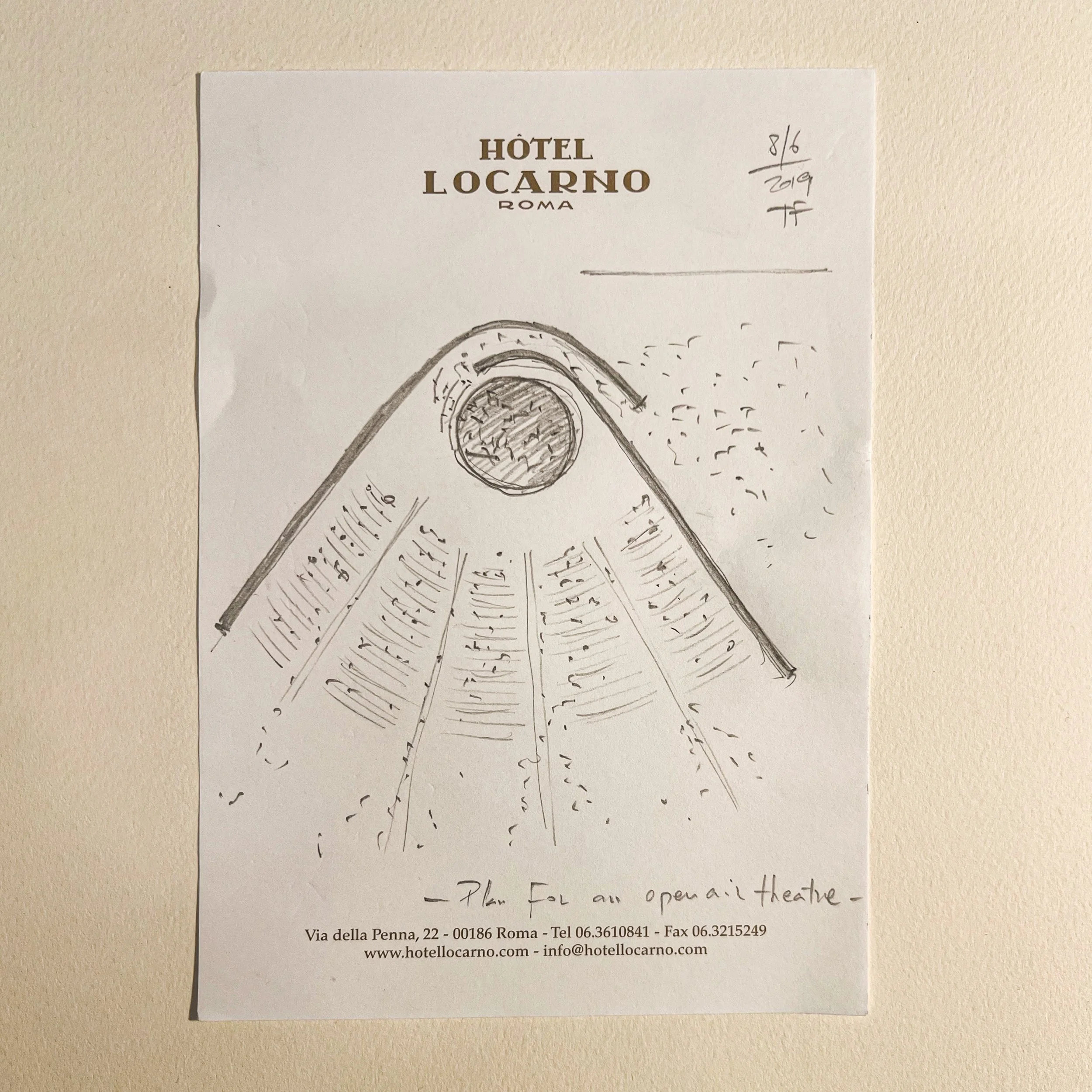 Sketch of a theater seating arrangement with a stage at the front and a large circular stage, sketched on the Hotel Locarno, Rome paper note.