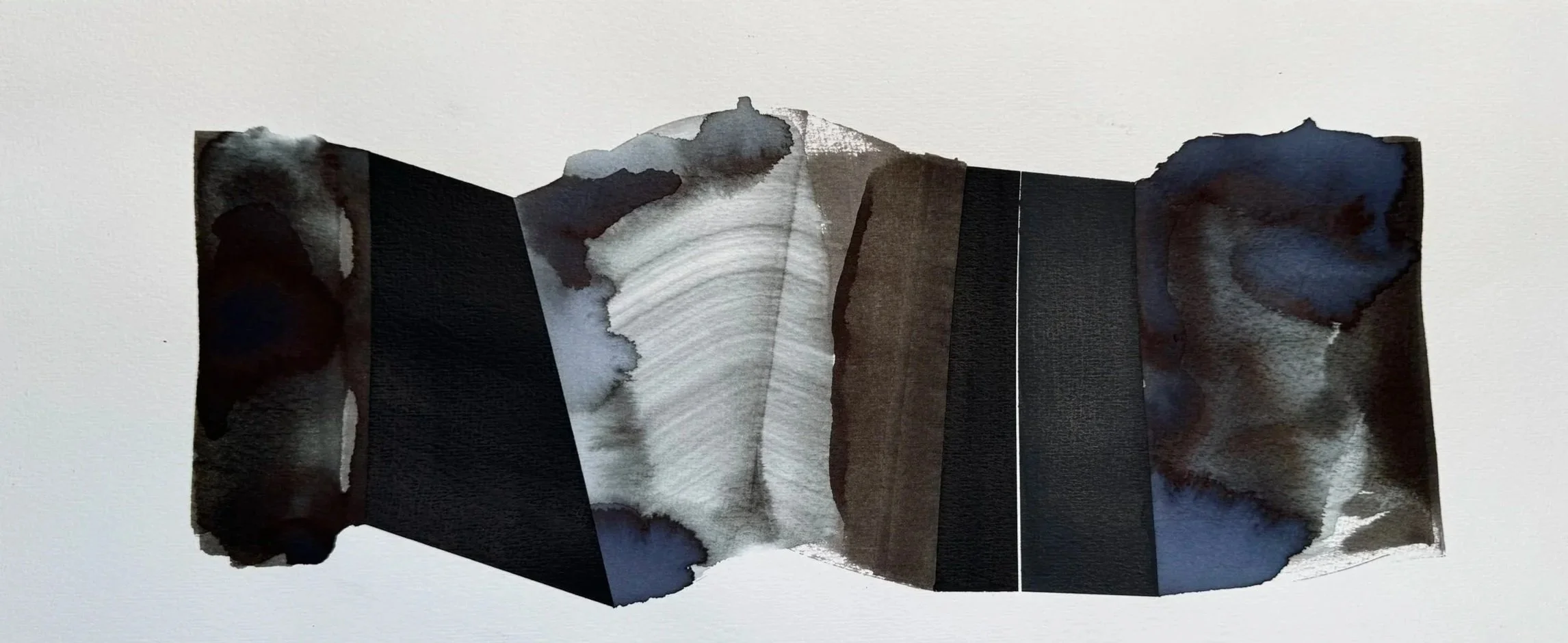 Une œuvre d'art abstraite composée de papier découpé et de peinture à l'encre noire, gris et blanc, assemblée pour créer un motif symétrique avec des formes organiques.