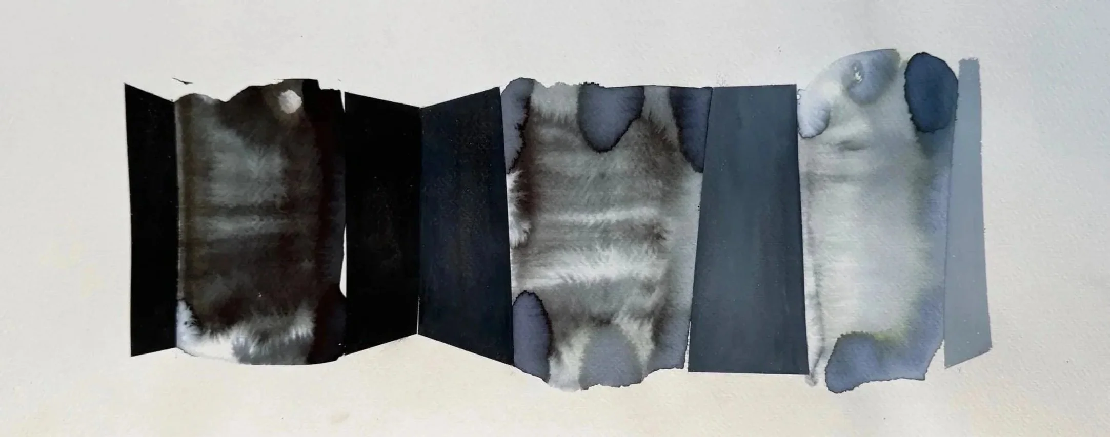 Une œuvre d'art composée de plusieurs morceaux de papier photo ou de toile, assemblés pour former une image de pelage de chat ou d'animal à motifs tachetés, avec des zones sombres et claires, fixés sur un fond blanc.