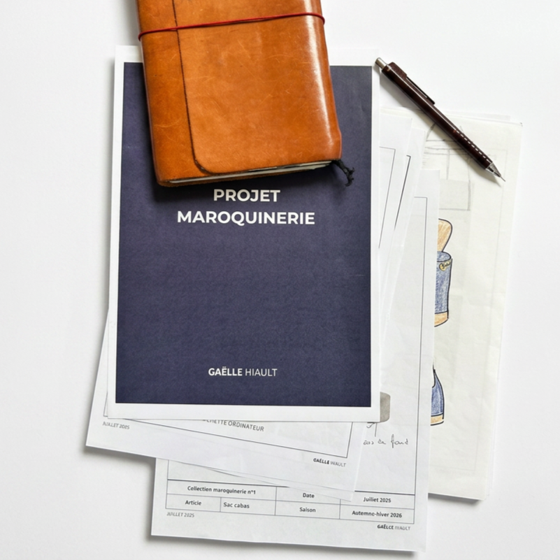 Manuscrit, carnet en cuir, et des documents liés à un projet de maroquinerie, avec un stylo posé à côté.