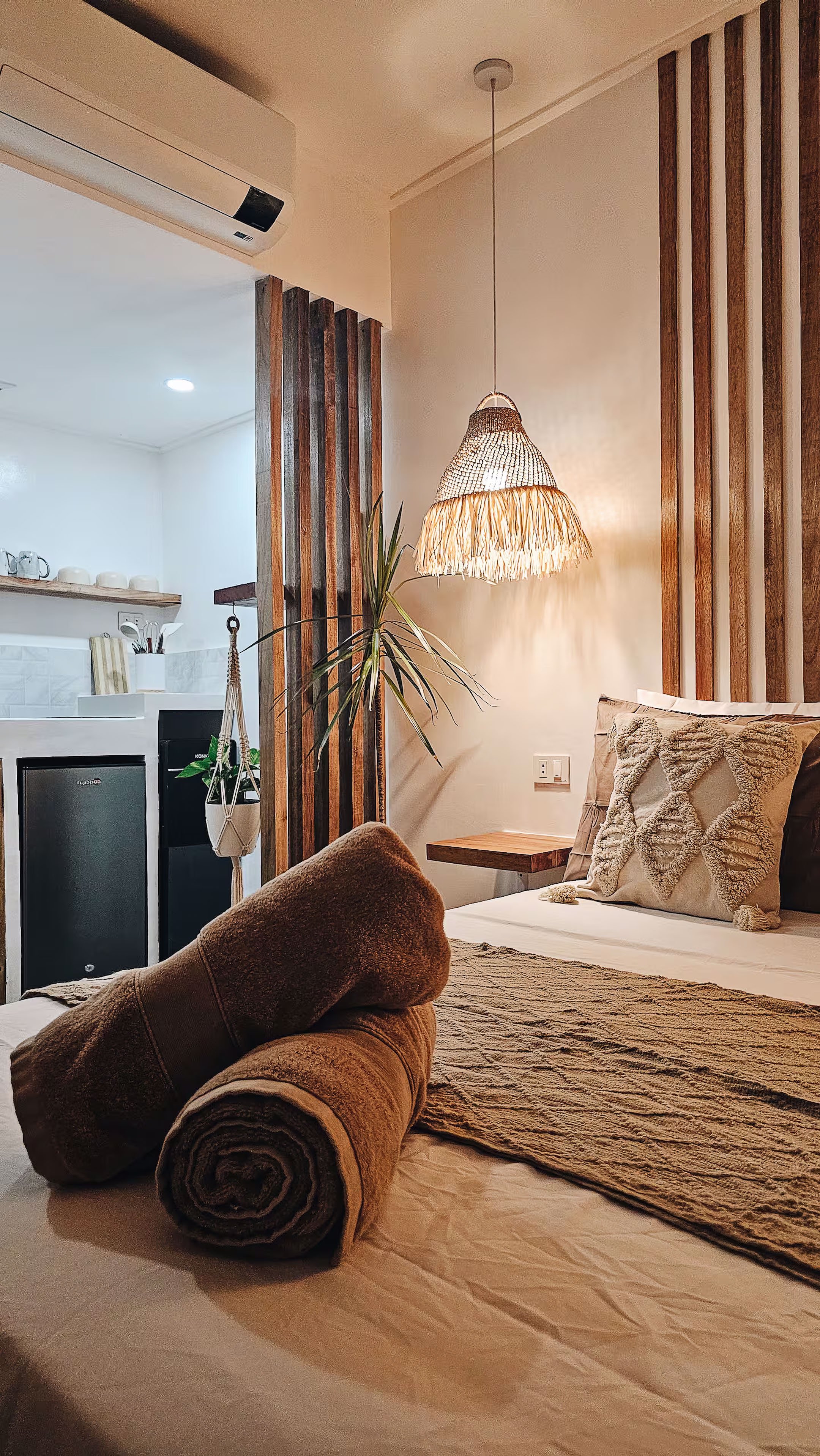 A warm, inviting view of Room 2 at Surf & Chill Siargao, featuring a cozy double bed beside a small kitchen space. Perfect for guests who love simple comforts and the ease of home-style living in General Luna.