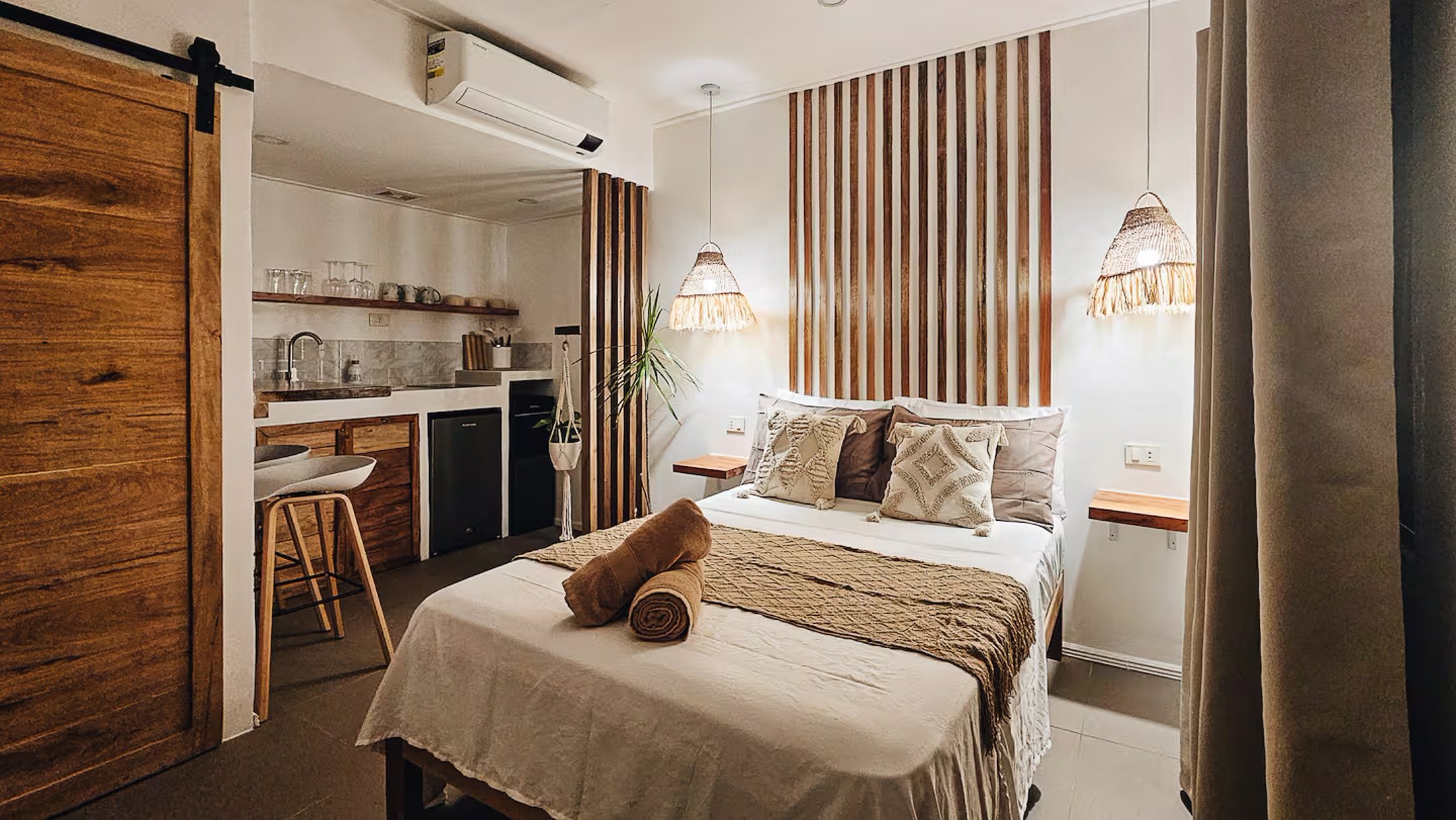 Warm and inviting guest room at Surf and Chill Siargao in General Luna featuring a double bed, private kitchen with basic cooking utensils, and natural wood accents in a modern tropical design.